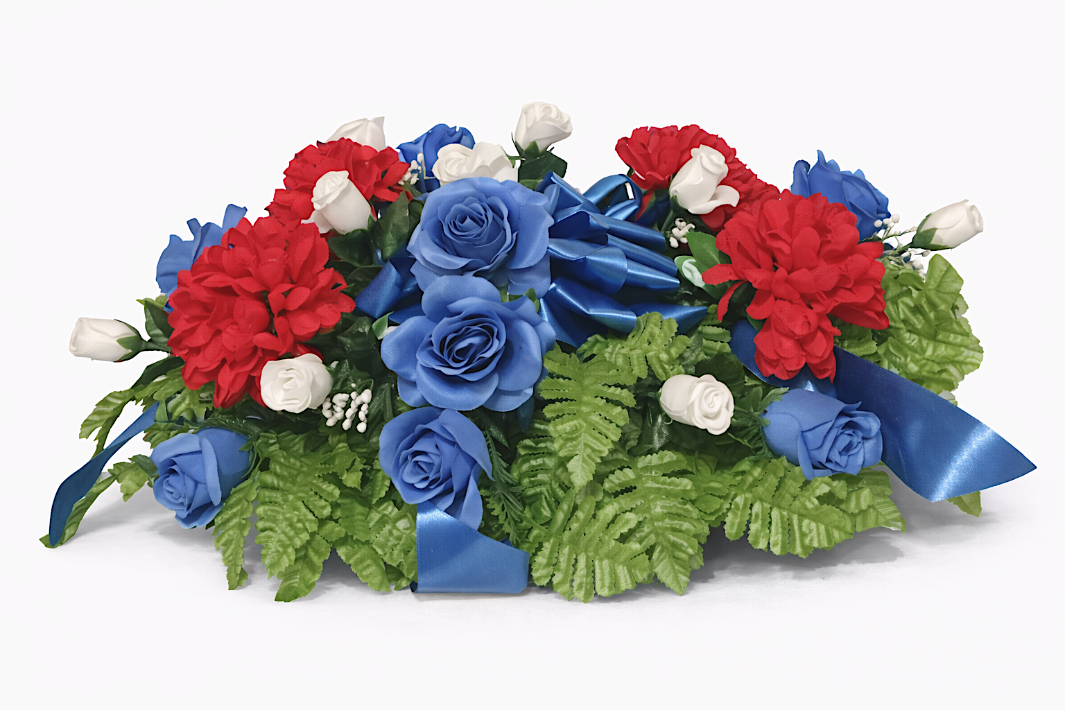 Floral arrangement with blue roses, red and white flowers, green foliage, and blue ribbon accents.