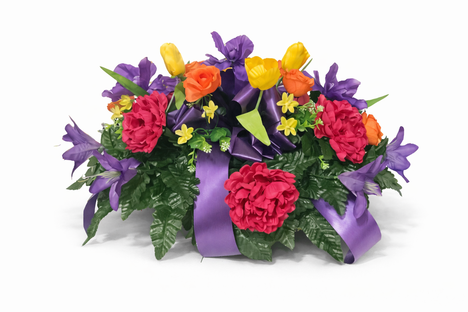 Colorful flower arrangement with purple, red, orange, and yellow flowers, green leaves, and a purple ribbon on a white background.