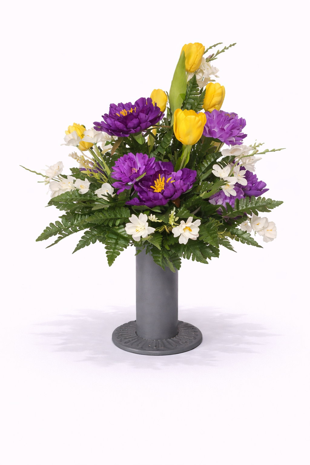 A colorful floral arrangement with purple, yellow, and white flowers in a gray vase.
