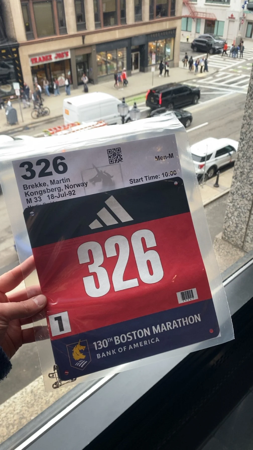 En person holder en startnummerlapp for Boston Marathon med nummer 326