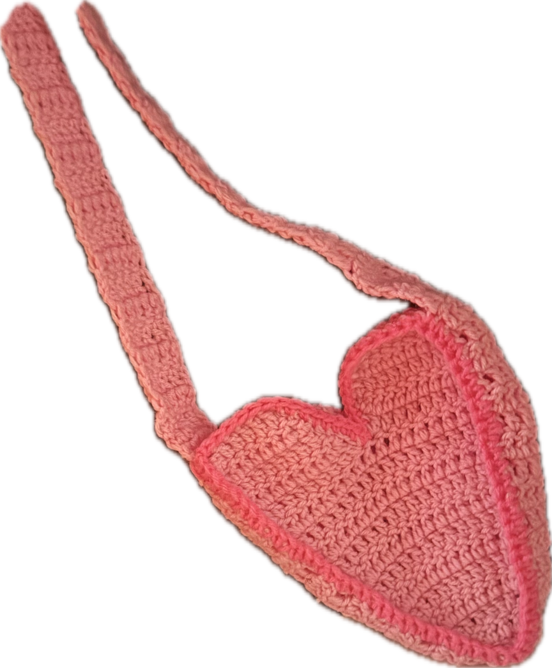 Crocheted pink heart with a long strap, against a black background.