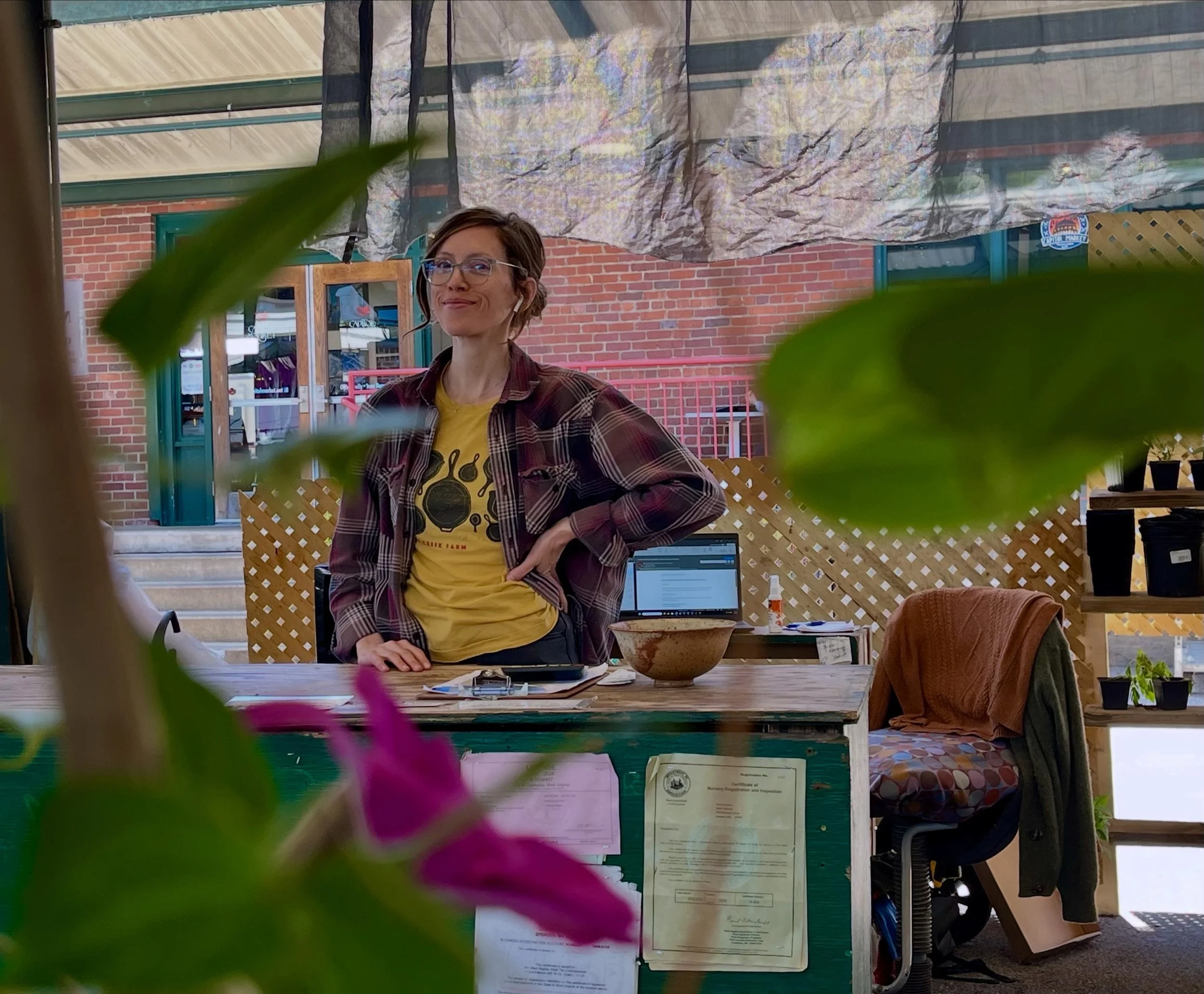 Liberty Newberry, the head of Wild Light Garden Collective, standing behind the nursery counter.