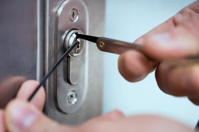 An image of a locksmith using a lock picking set. Text above highlights the reasons why there are difference in prices based on areas and text below that highlights how a locksmith generates their prices.