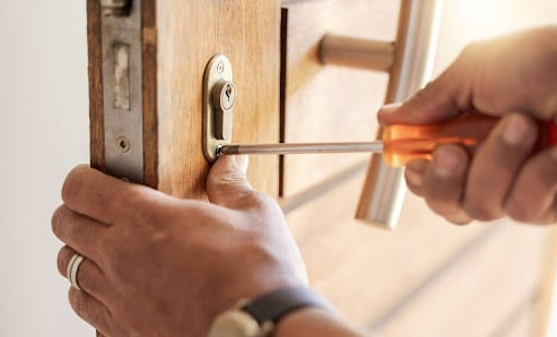 An image of a locksmith applying a euro cylinder guard, with text to the left explaining how Locksmithery are a locksmith service provider in Bordon and how they seperate themselves away from their competitors.