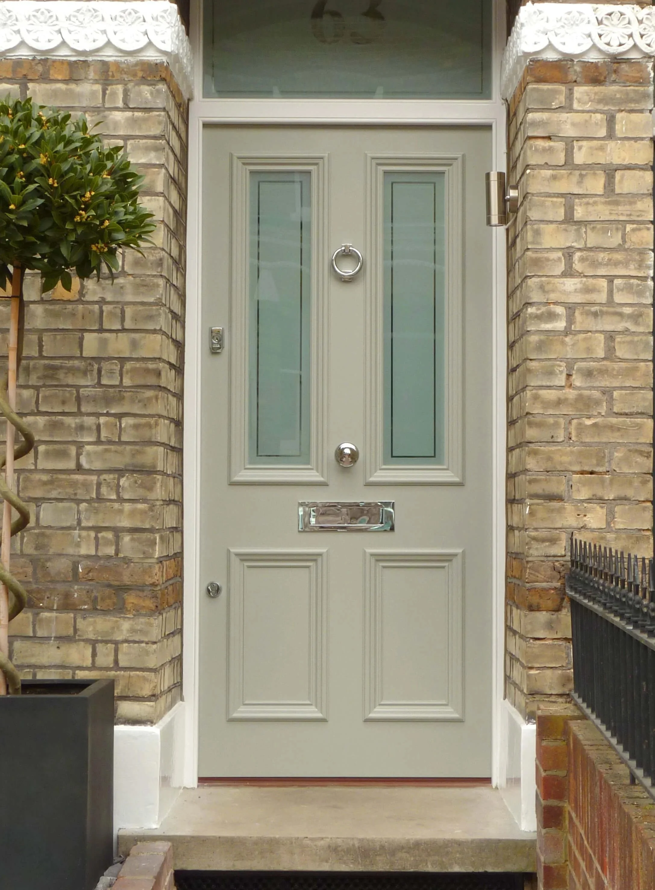 A cream front door with 2 glazed windows with text to the right highlighting Locksmithery now being in Surrey and Hampshire.