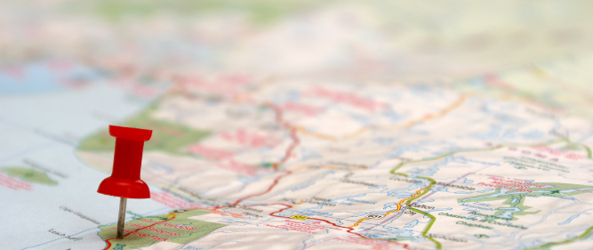 An image of a map with a red pin on a major road. Text is to the left explaining why there are differences in costs based on the location you like in the UK