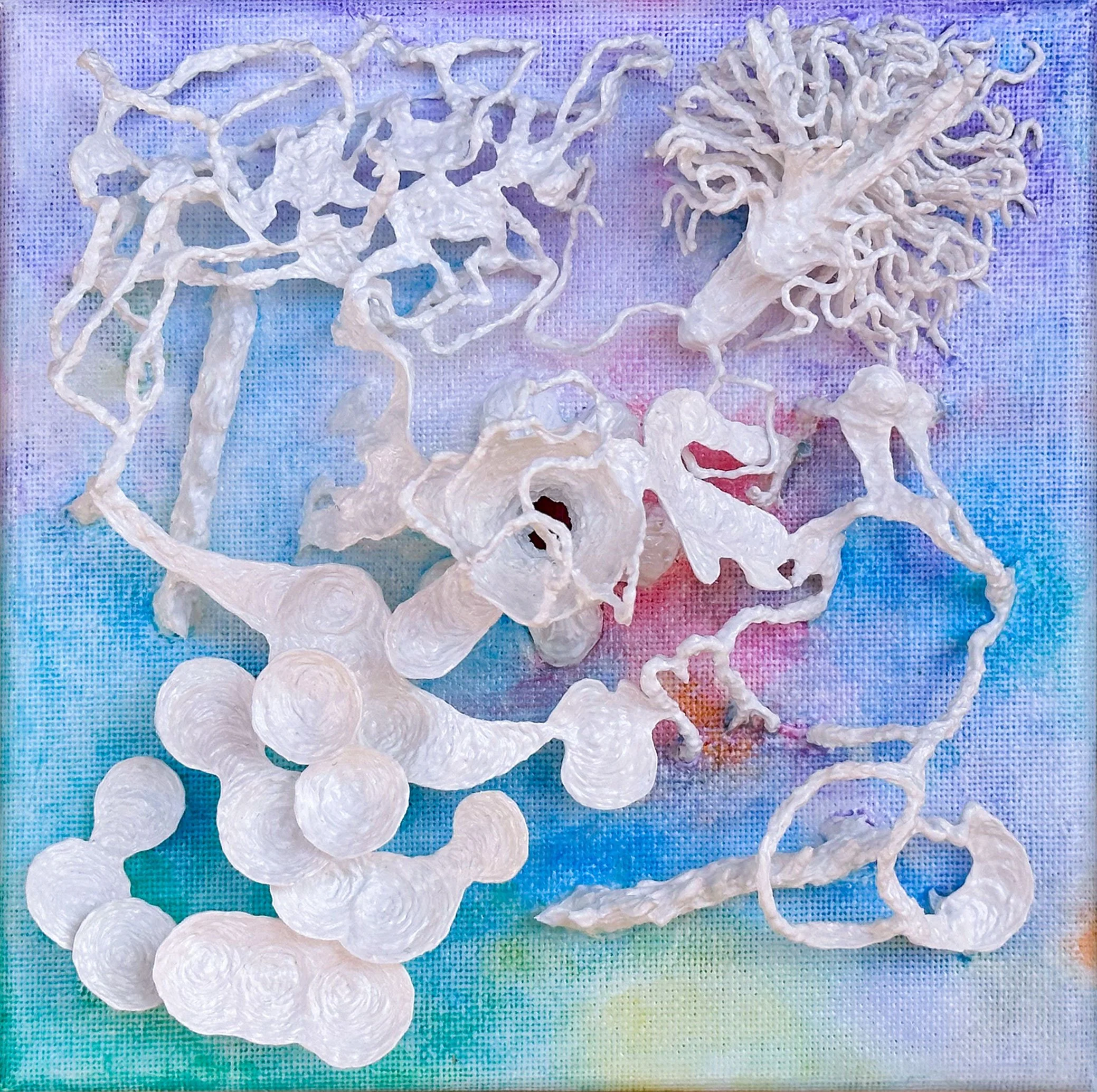 A collection of white, textured, tangled paper or plastic strips arranged on a colorful, tie-dye fabric background.