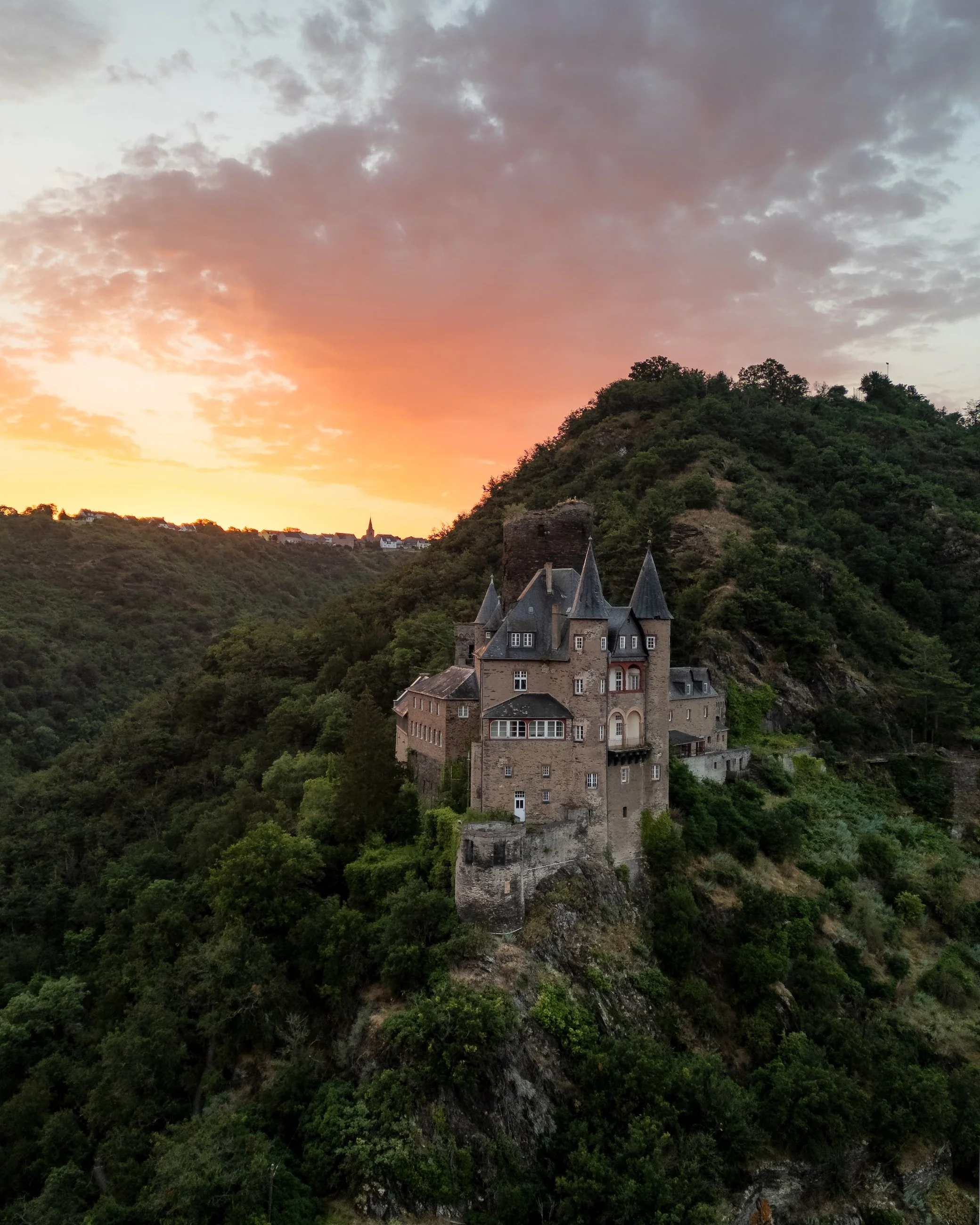 Burg auf einem Hügel bei Sonnenuntergang in der Natur.