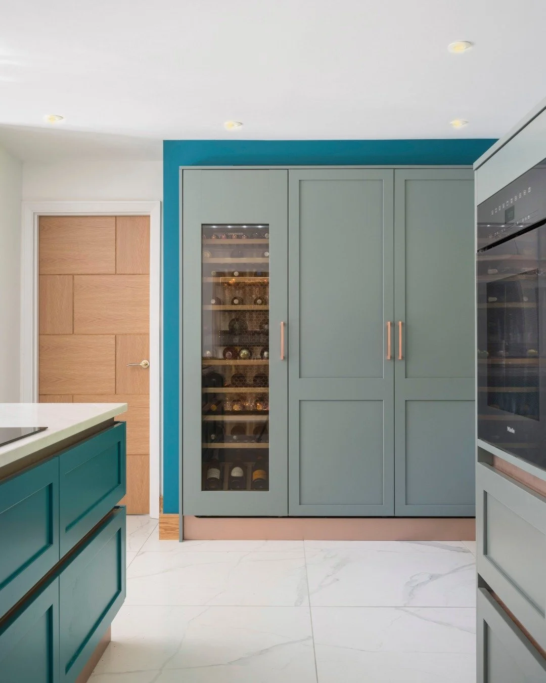 Two tones, one brief: make it confident.

This contemporary kitchen features a modern slim painted shaker frontage - Sage Green for the perimeter, Mint Green for the island - with a copper recessed finger rail and matching plinth adding warmth and co