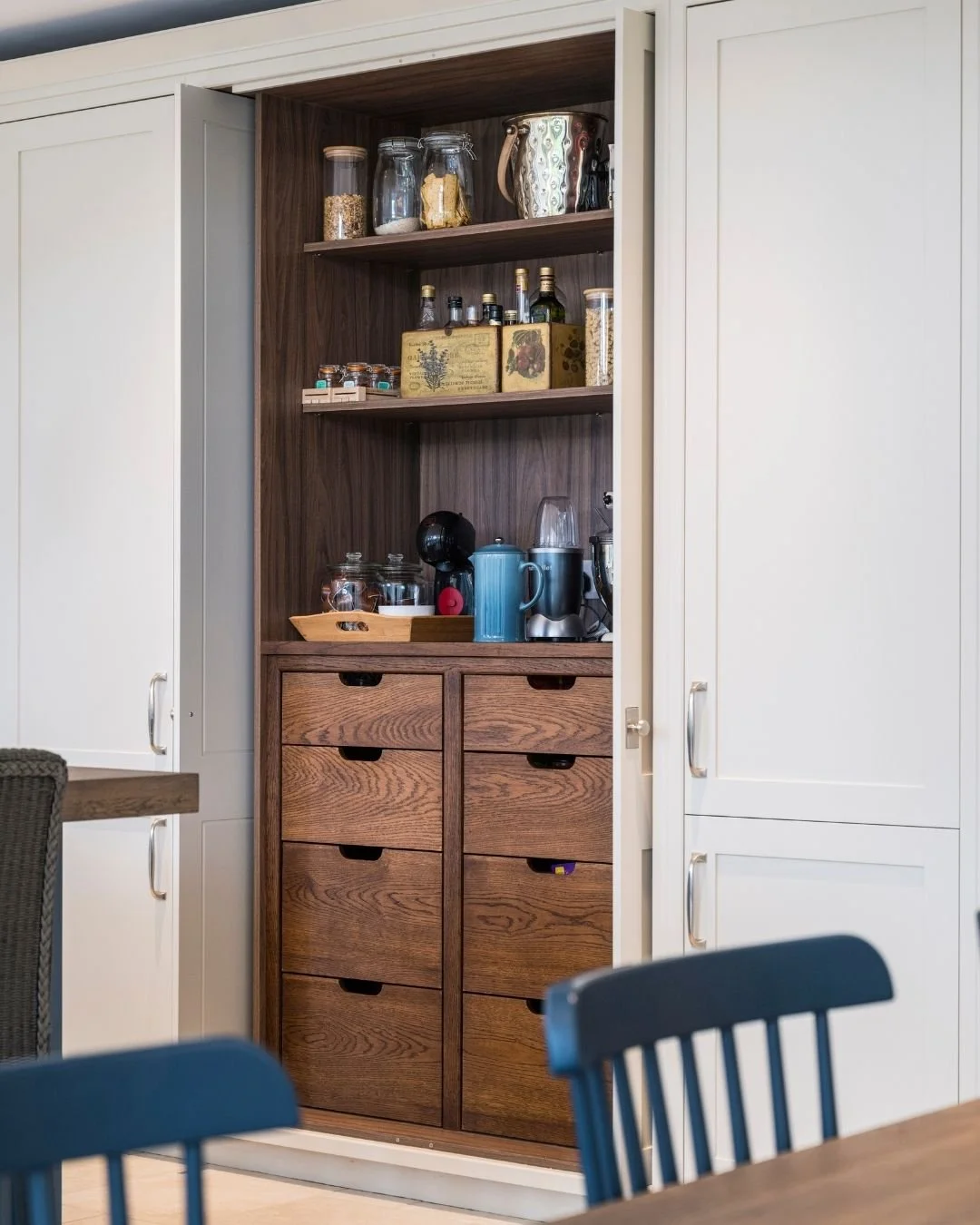 Behind the pocket door, a dark stained oak veneer interior houses a dedicated coffee station &mdash; accessible throughout the day and closed away when not in use.

This is what a larder should do. Not just store things, but give every element of the