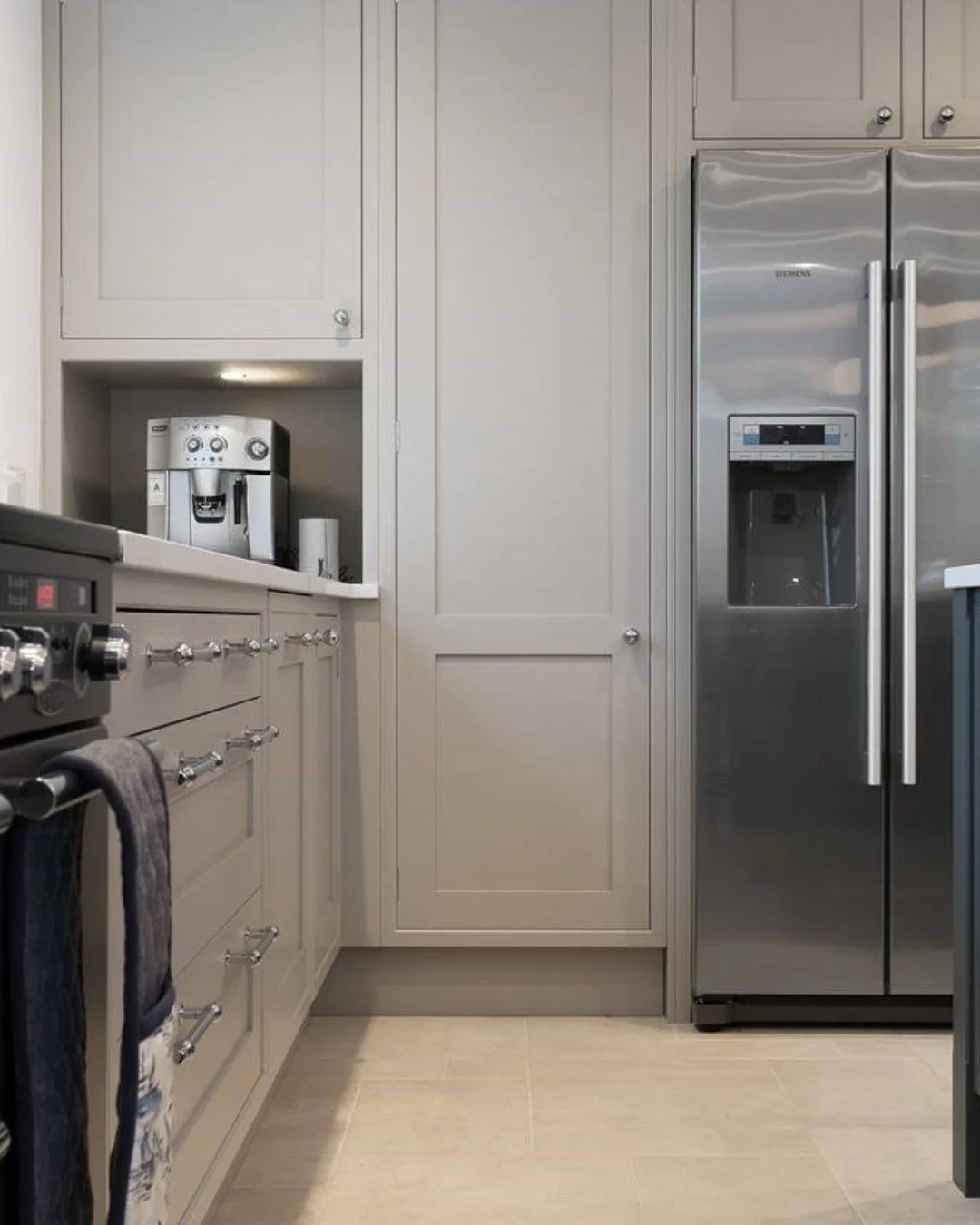 An American-style fridge freezer integrated flush into a run of grey shaker cabinetry.

The brief was seamless - no appliance should interrupt the line of the kitchen. Our team specified the fridge housing, planned the cabinetry run around it and fin
