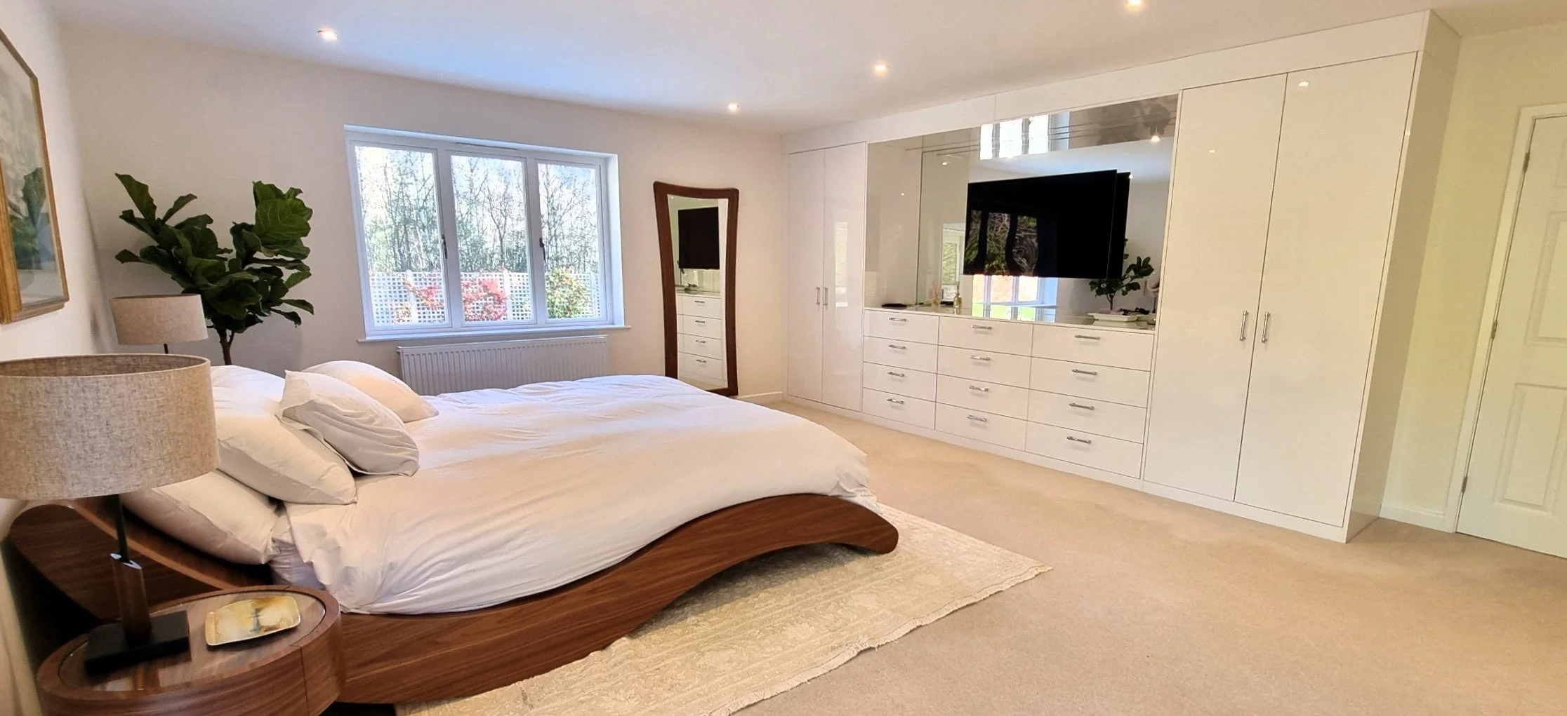 View of an open walk-in closet with shelves and hanging clothes visible, seen through a doorway with partial walls on either side.