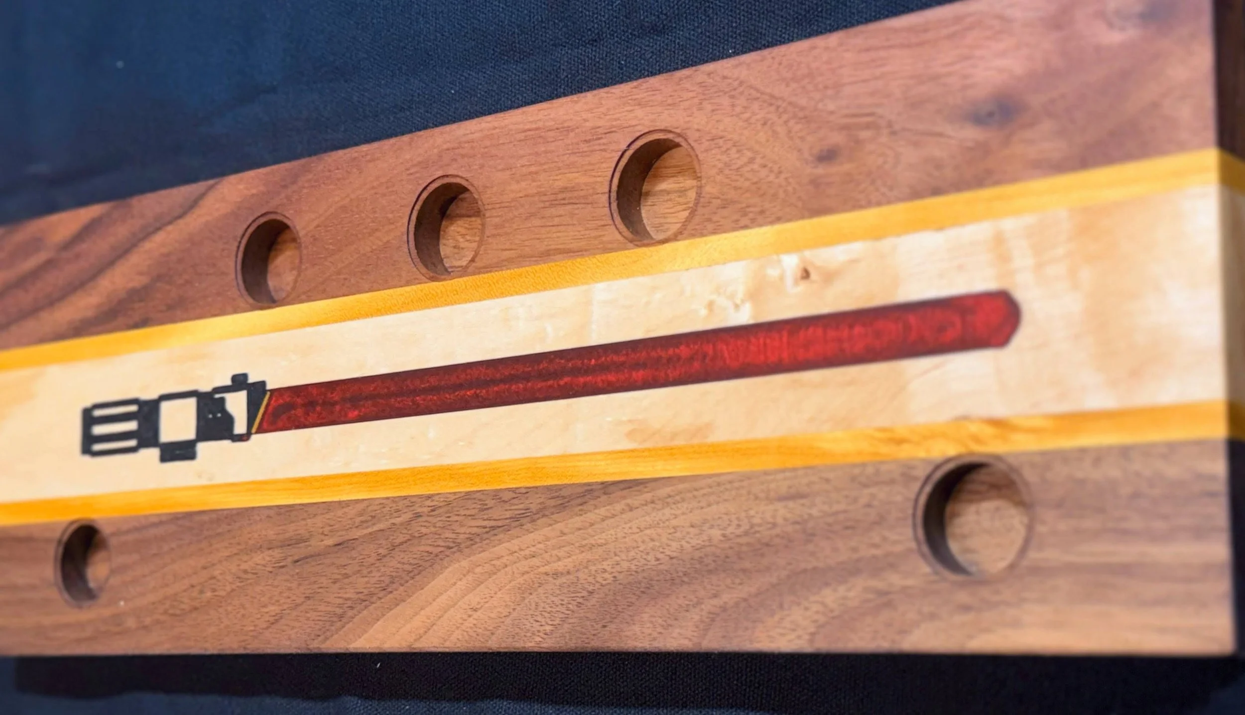 Close-up of a wooden wall with a epoxy inlay lightsaber.