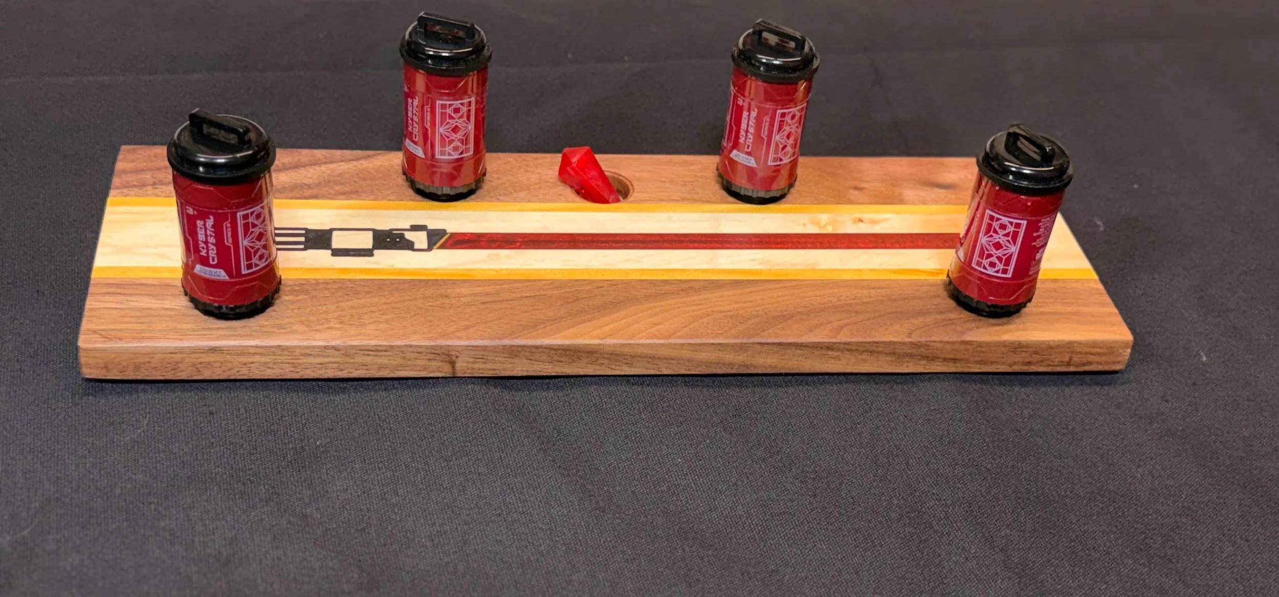 A tabletop kyber crystal holder with epoxy lightsaber inlay. 