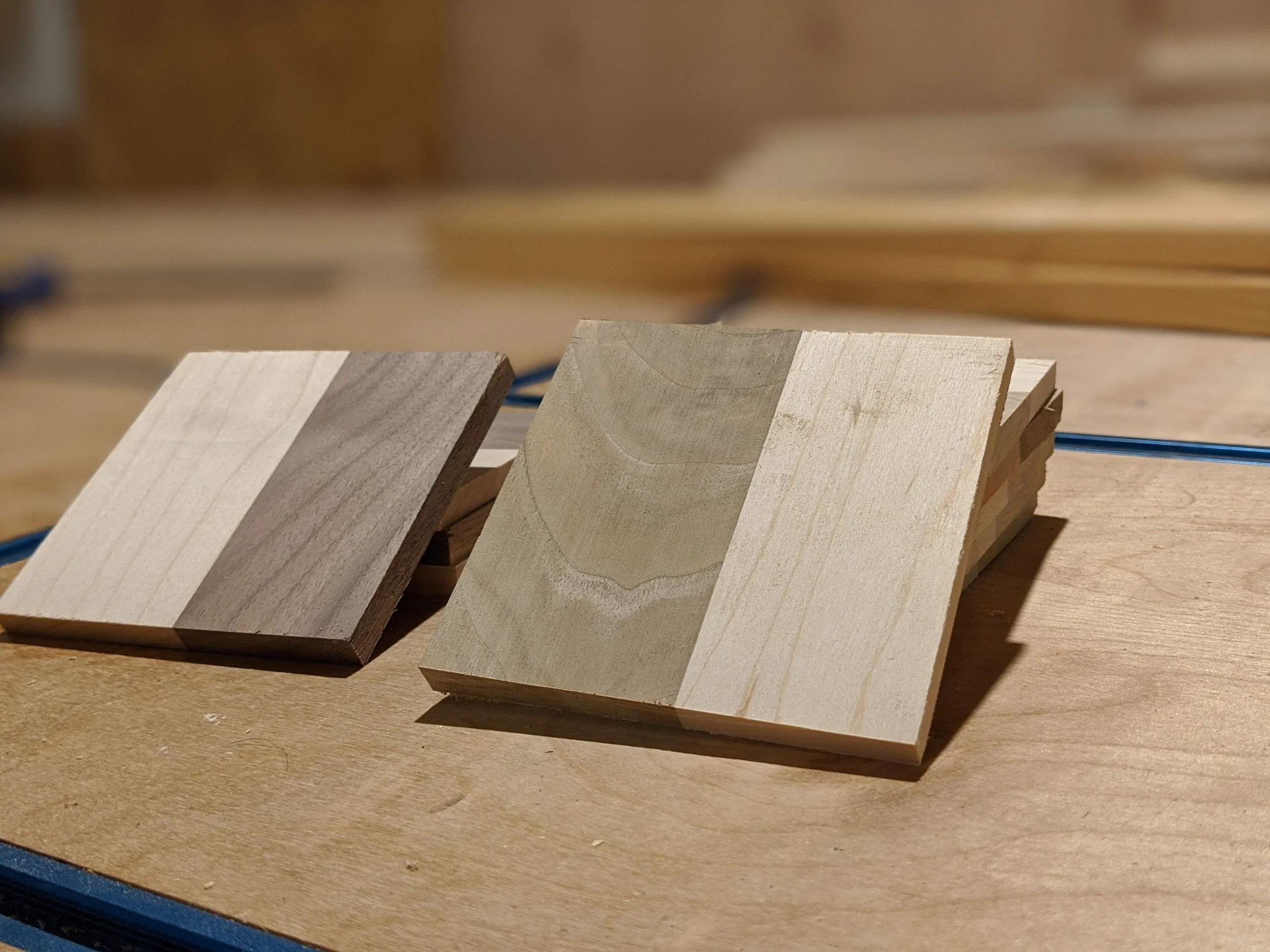 Two pieces of wood with contrasting natural colors and grain patterns, placed on a wooden surface.