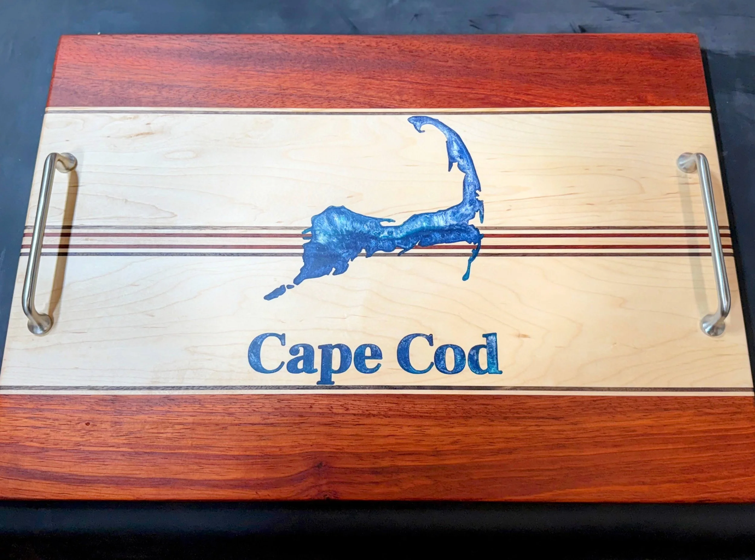 Wooden tray with a map of Cape Cod in blue and the words "Cape Cod" written below it.
