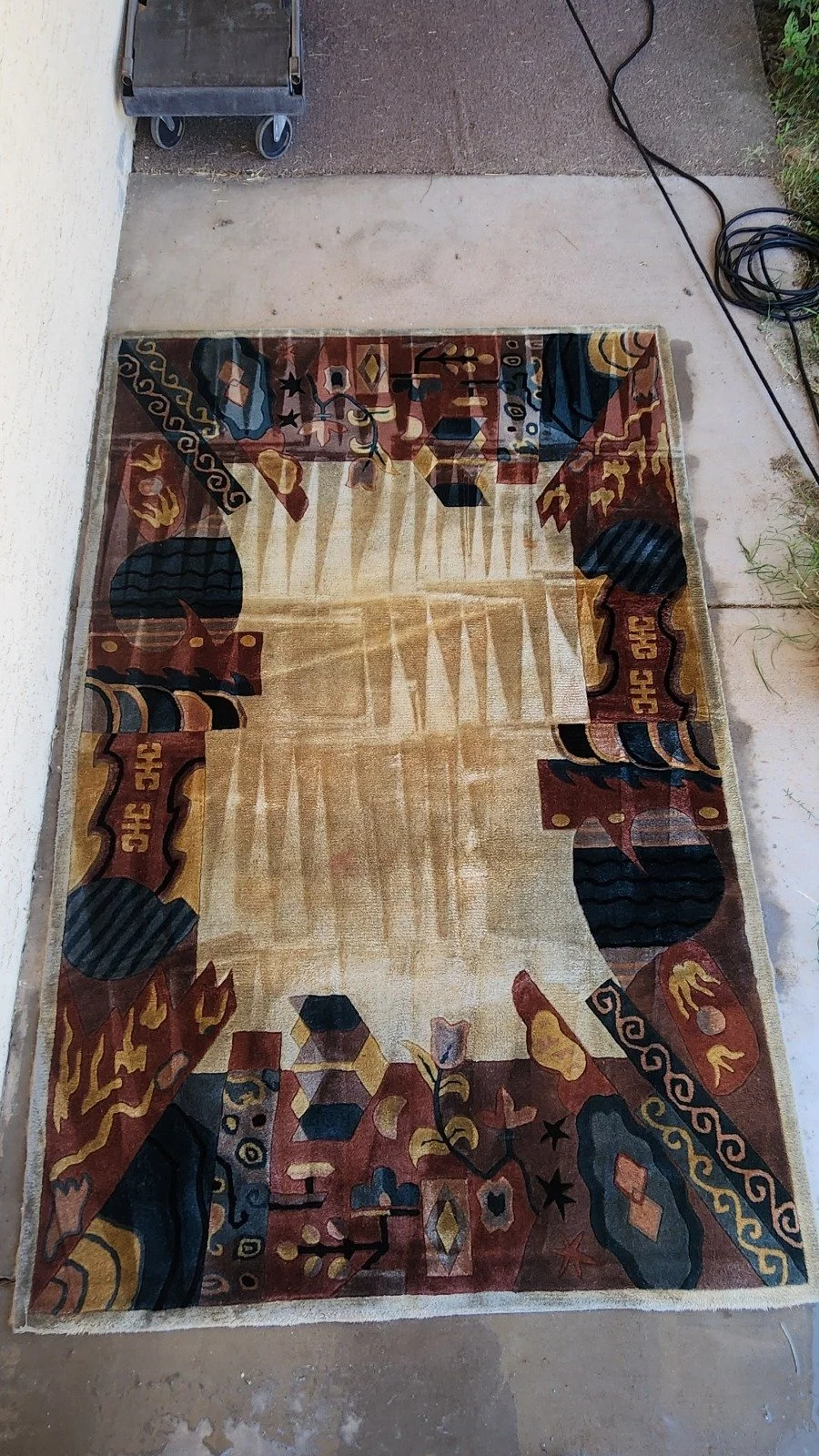 Colorful abstract patterned rug on a concrete porch that was deep cleaned