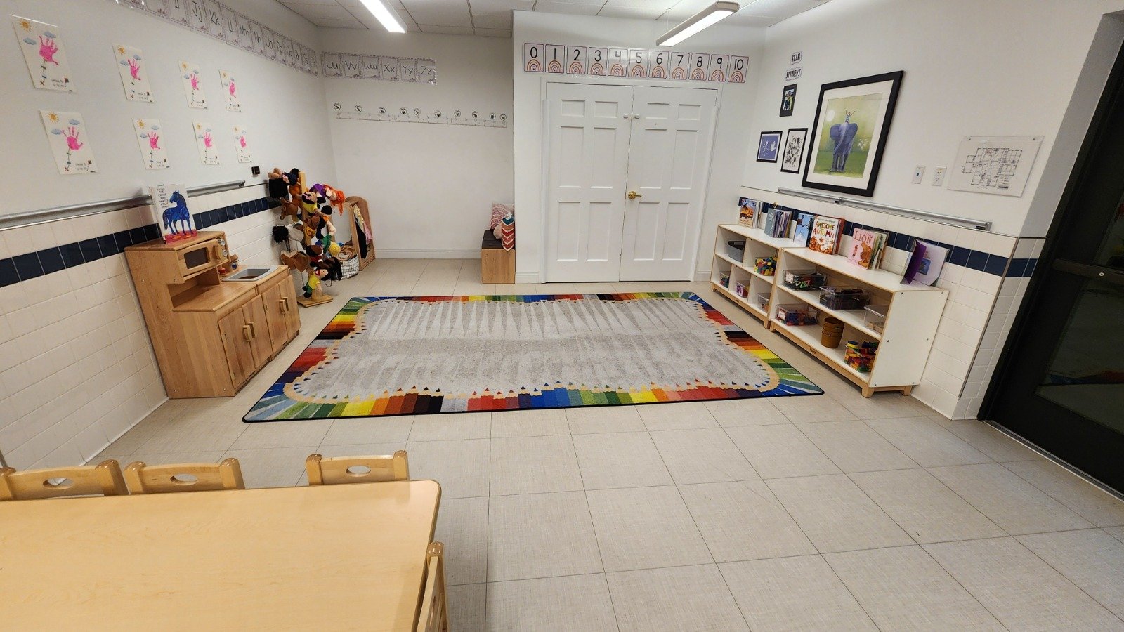 Empty preschool classroom corner with a rainbow rug that was professionally cleaned