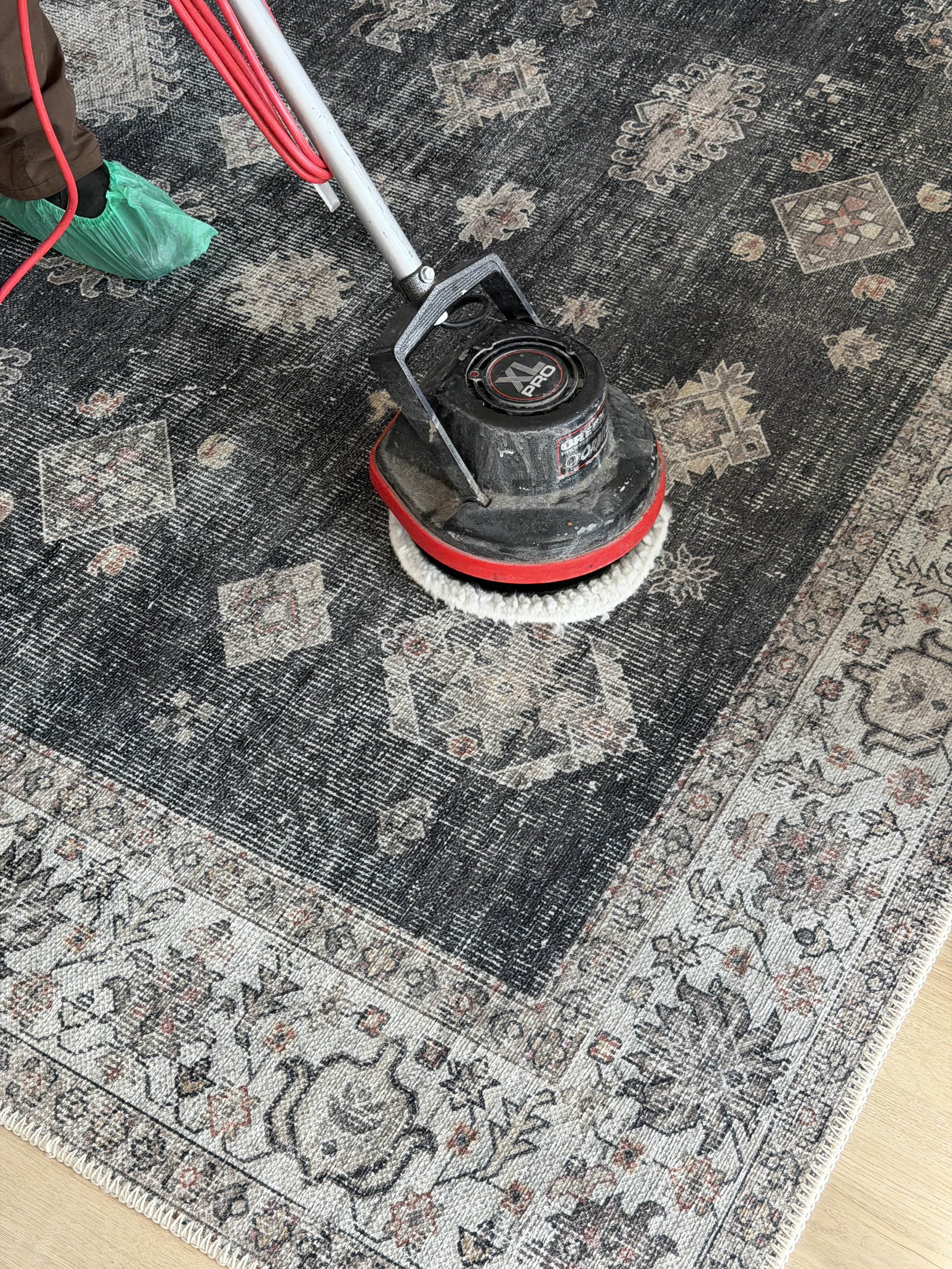 A rotating machine scrubbing a cotton rug