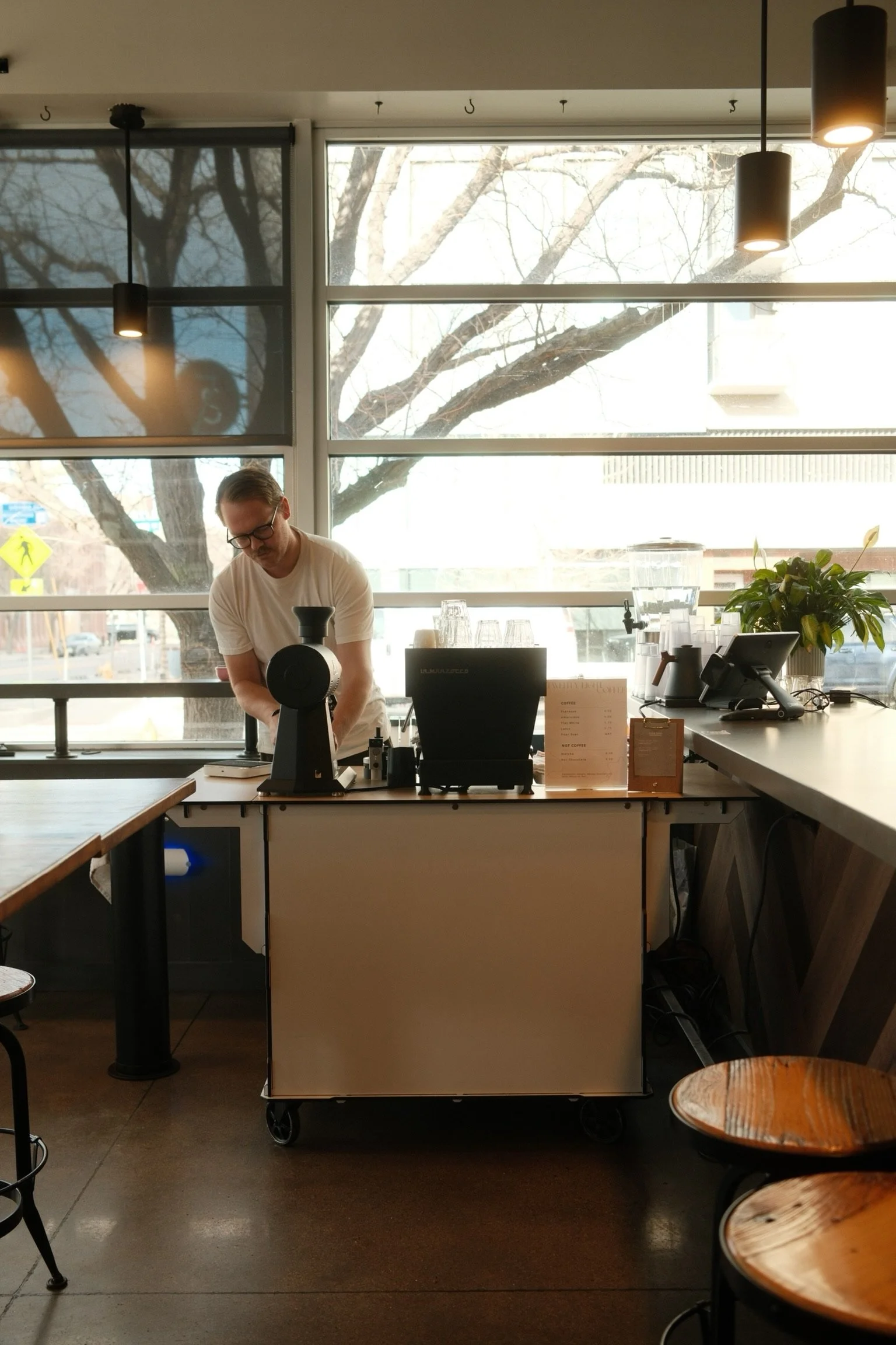 Specialty coffee barista preparing espresso drinks at a catering coffee cart.