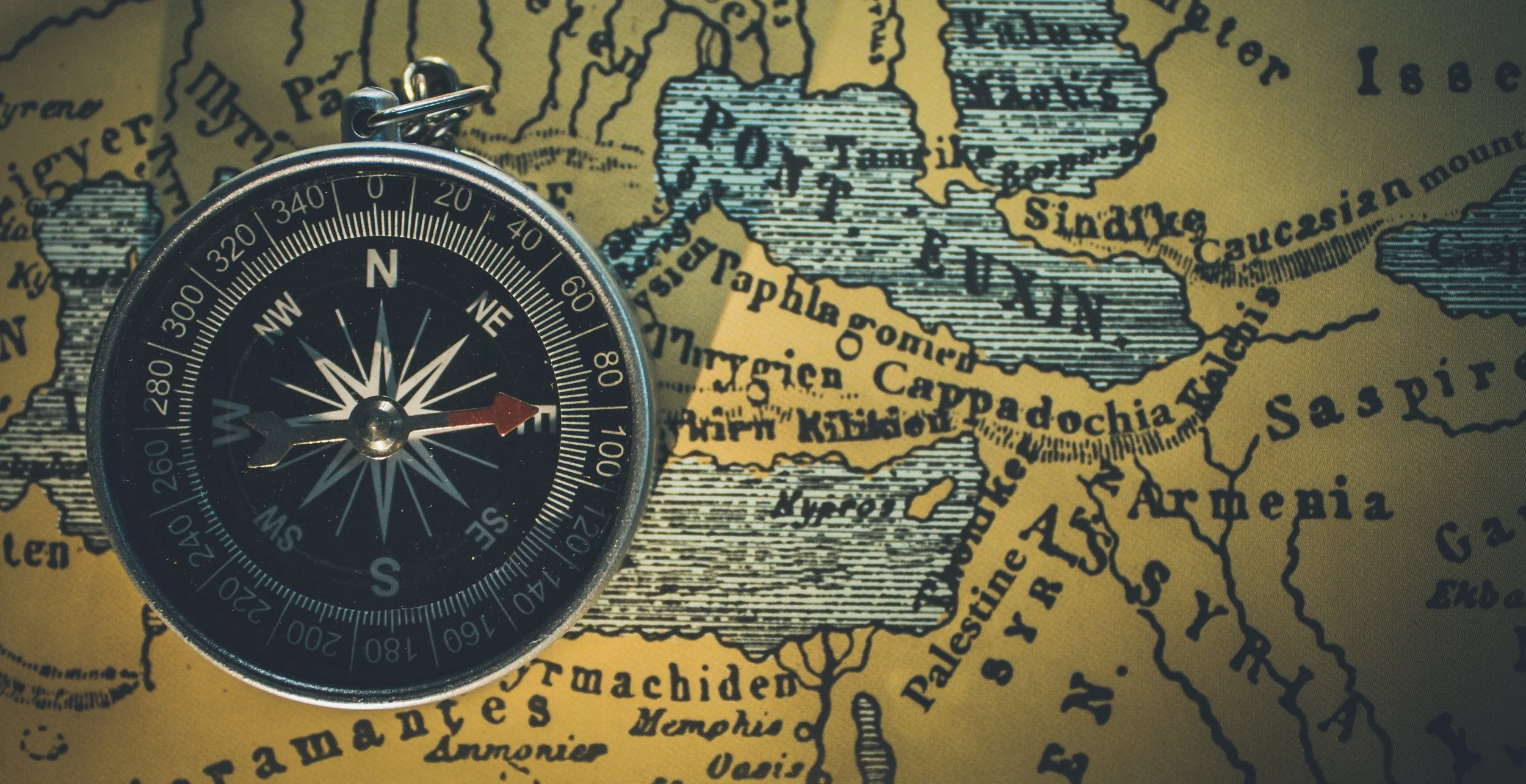 A compass placed on a map showing parts of the Middle East and Central Asia.