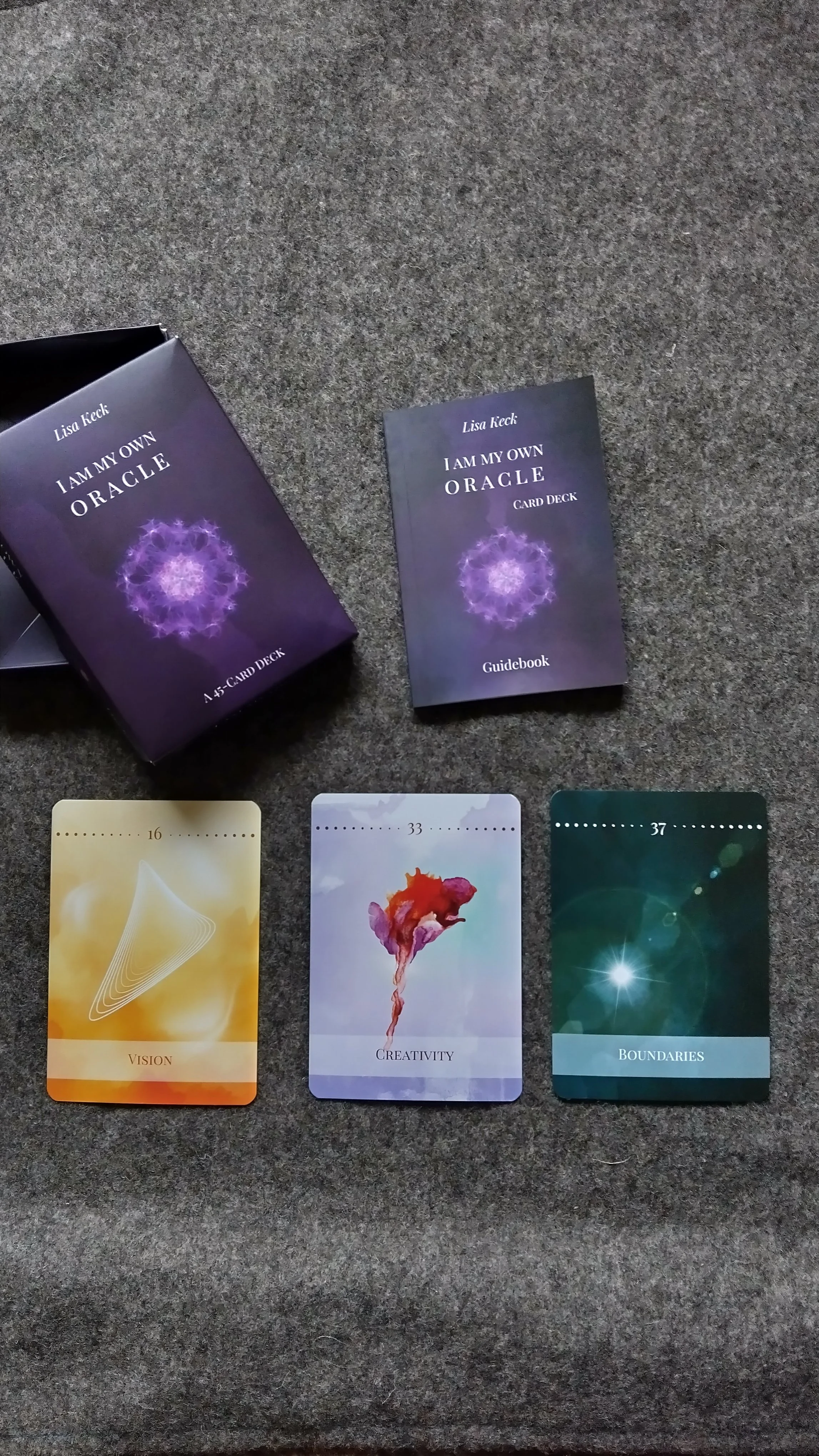 Bild zeigt ein Kartenspiel namens "I Am My Own Oracle" mit drei ausgelegten Karten: Vision, Creativity und Boundaries, sowie eine Anleitung und eine Kartenbox.