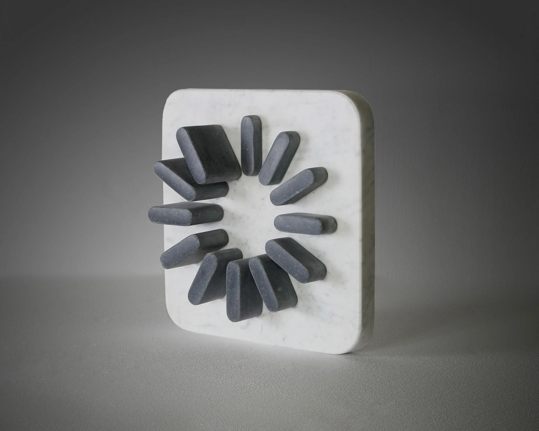 Modern wall clock with a white marble square face and black rectangular hands arranged in a radial pattern