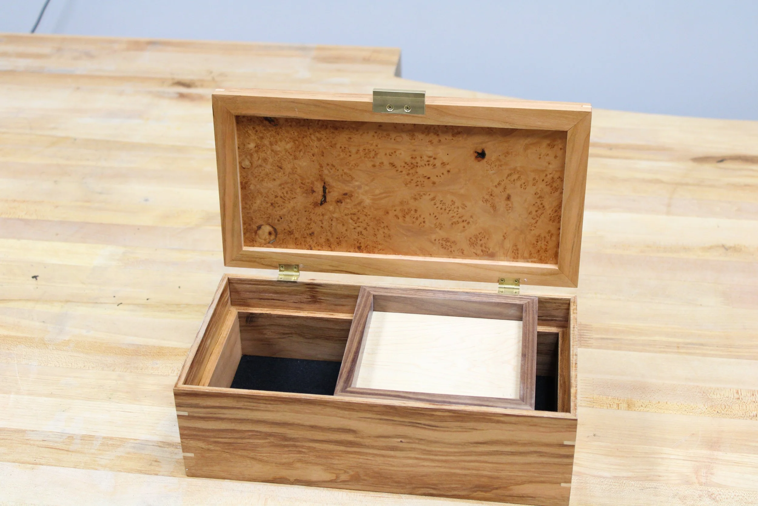 Open wooden box with a removable smaller box inside, placed on a wooden table, built by a woodworker at The Woodwork Shop.