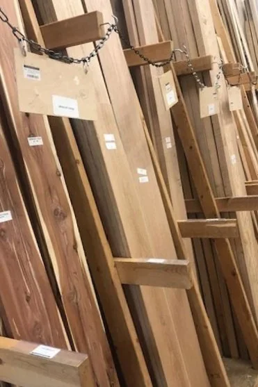Wooden slabs displayed vertically, some chained together, in a hardware store.