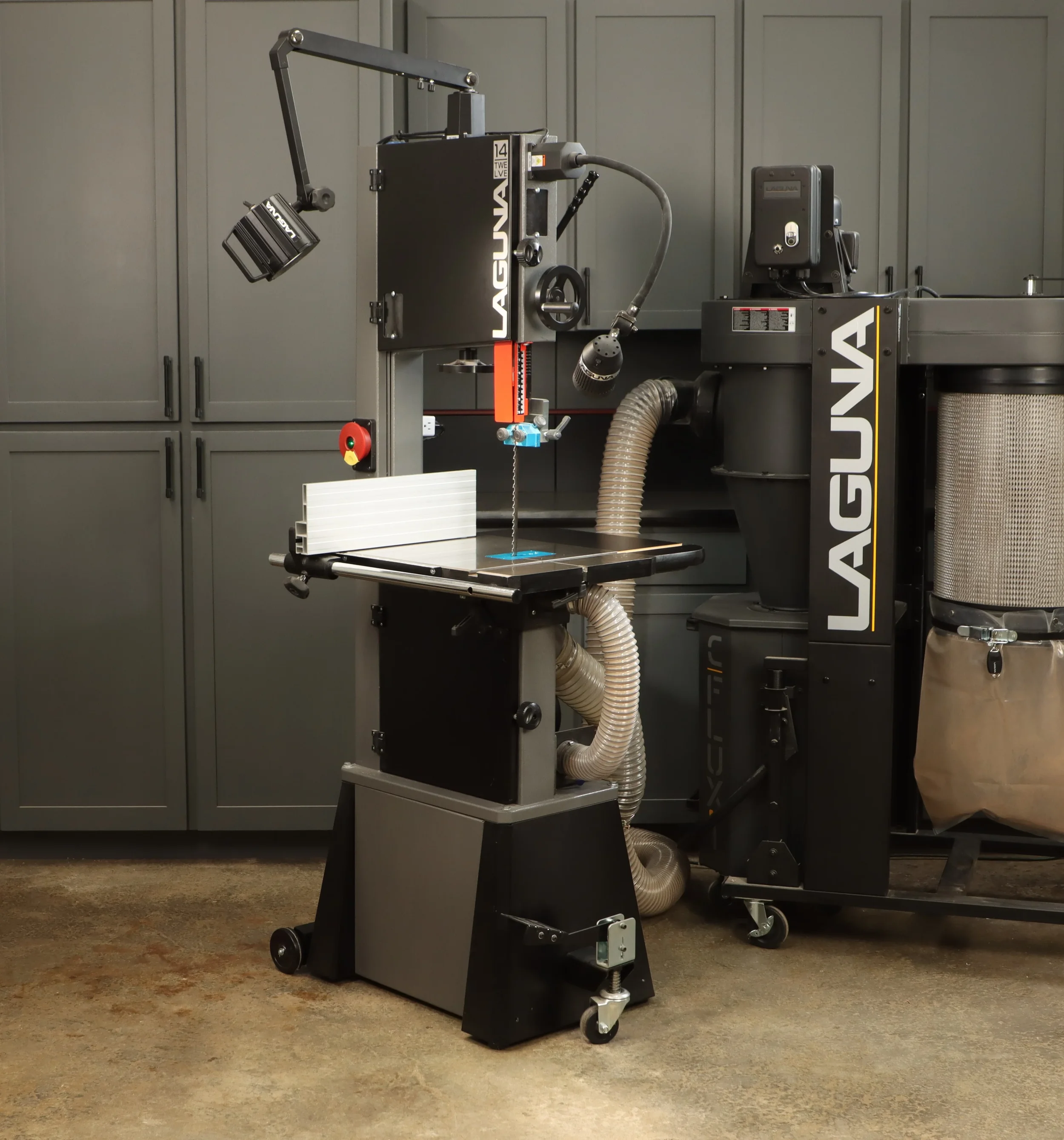 A Laguna bandsaw in a workshop or studio setting, surrounded by gray cabinets and a brown concrete floor.