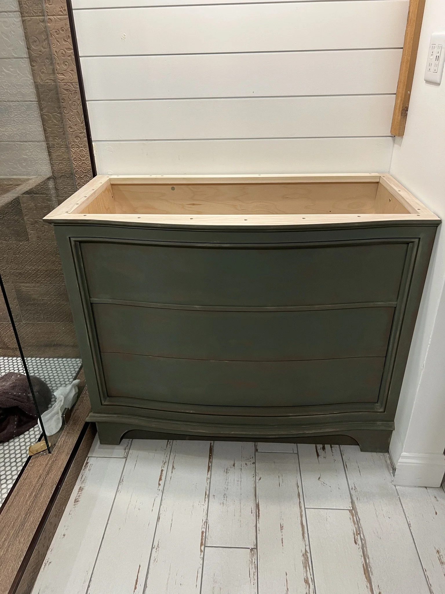 A wooden dresser with a curved front, painted green, built by a woodworker from The Woodwork Shop.
