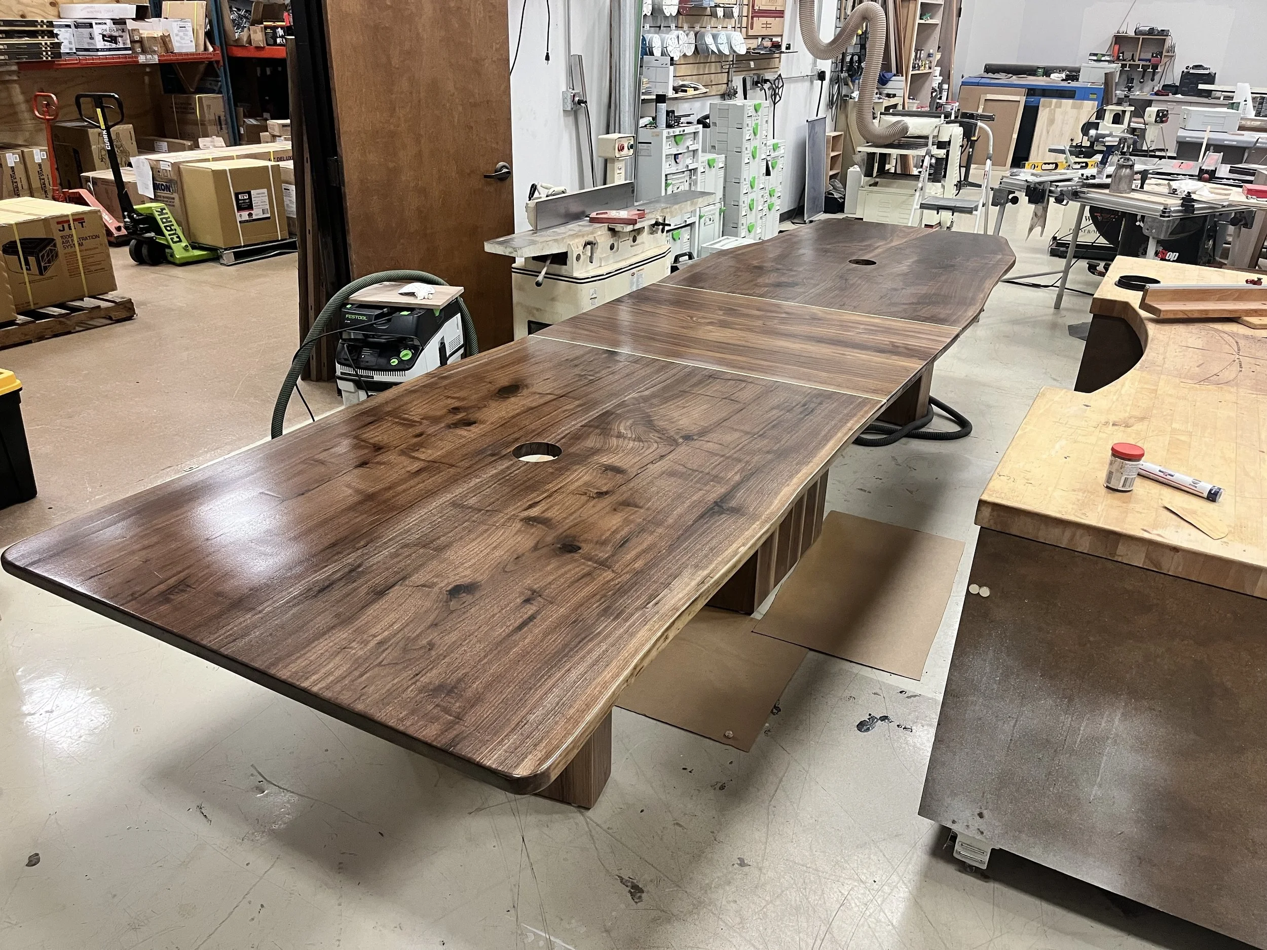 A large conference workshop table with a natural, glossy finish built by woodworkers from The Woodwork Shop.