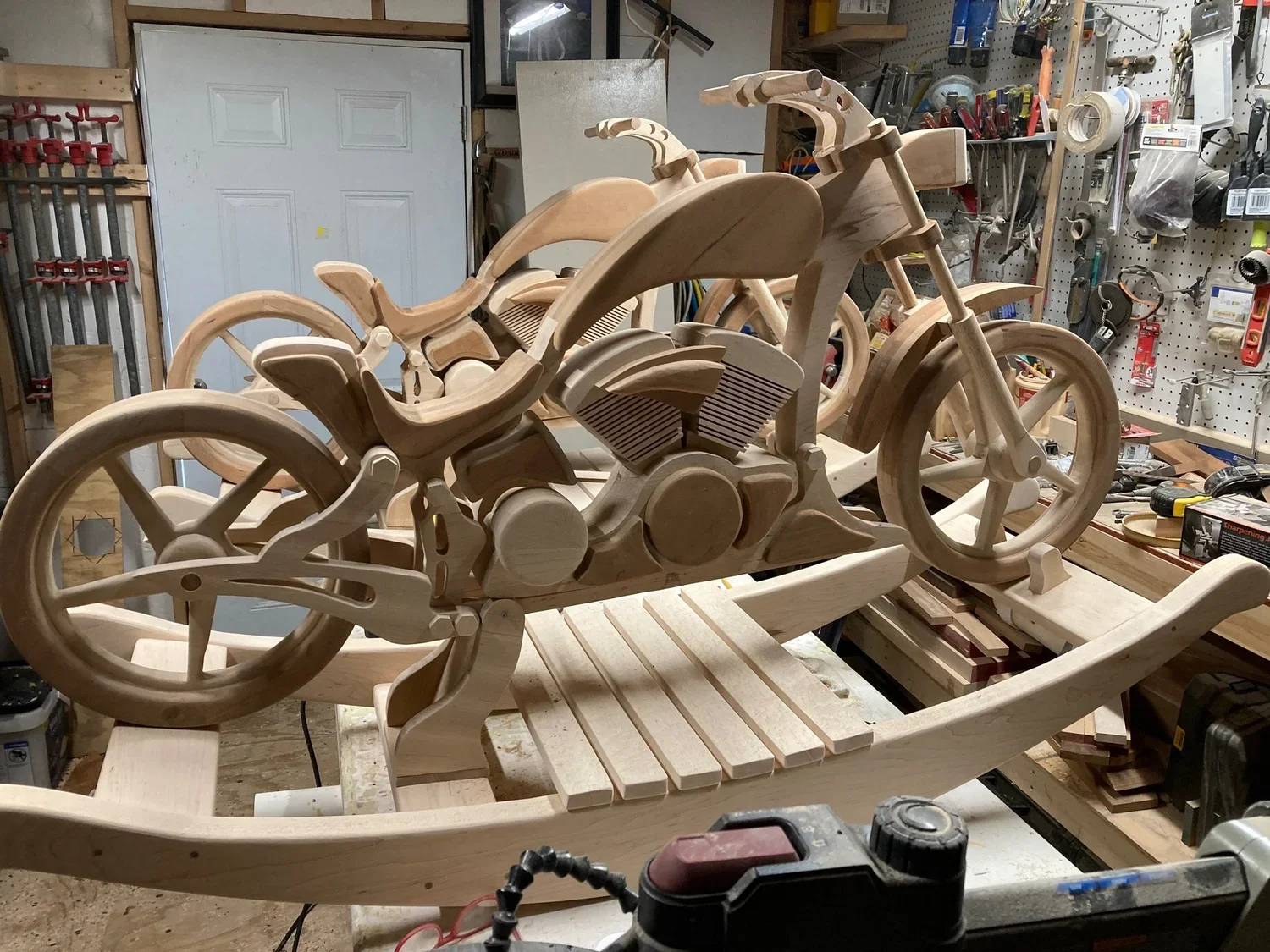 Un modelo de trineo y motocicleta de madera en un taller de carpintería.