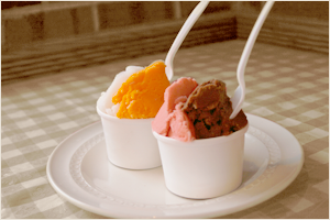 Two cups of ice cream with different flavors on a white plate