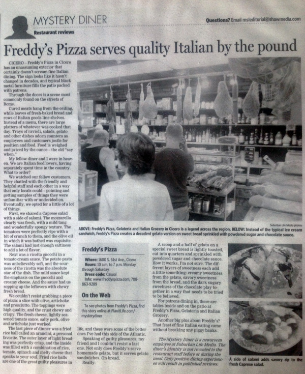 Newspaper article titled 'Freddy’s Pizza serves quality Italian by the pound' with a photograph of people ordering at Freddy’s Pizza counter, displaying shelves with supplies and hanging cured meats.