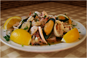 Seafood salad with lemon wedges on a white plate