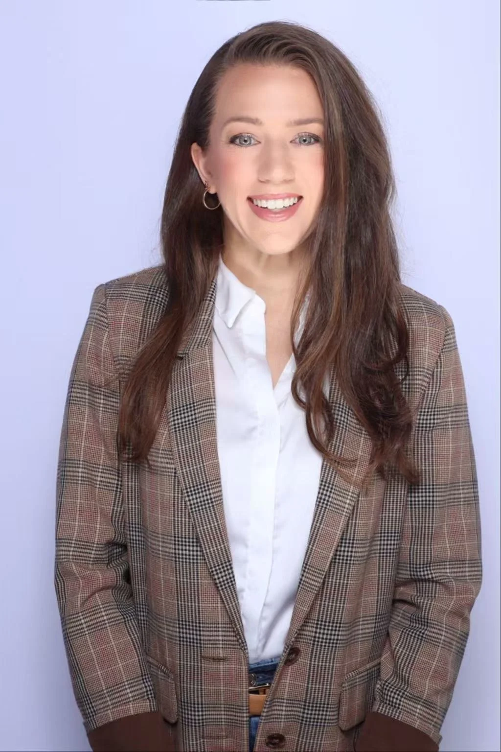 Professional photo of Lindsay, smiling in a brown blazer and white shirt.