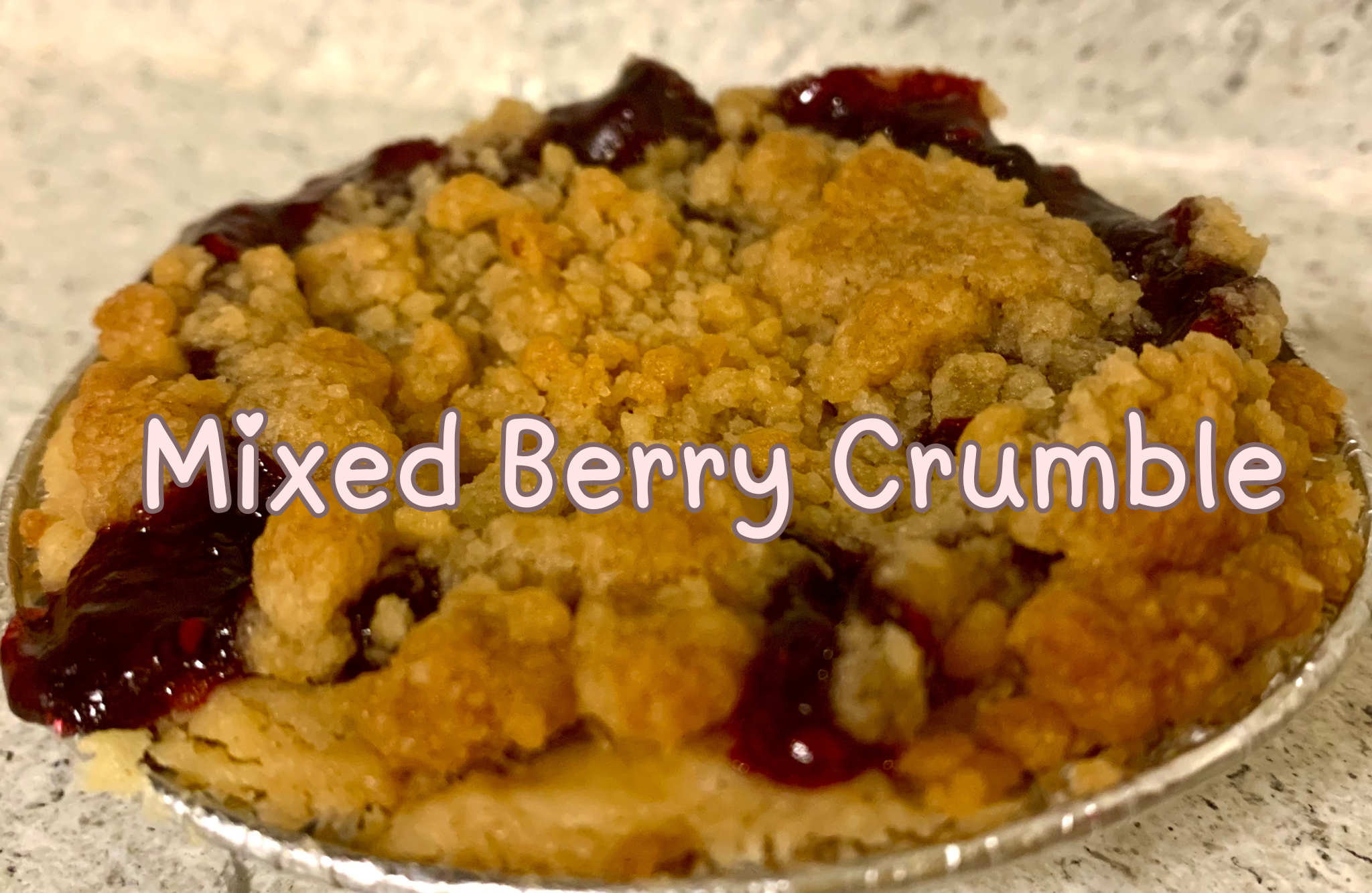 Mini mixed berry crumble pie with baked fruit filling and crumb topping.