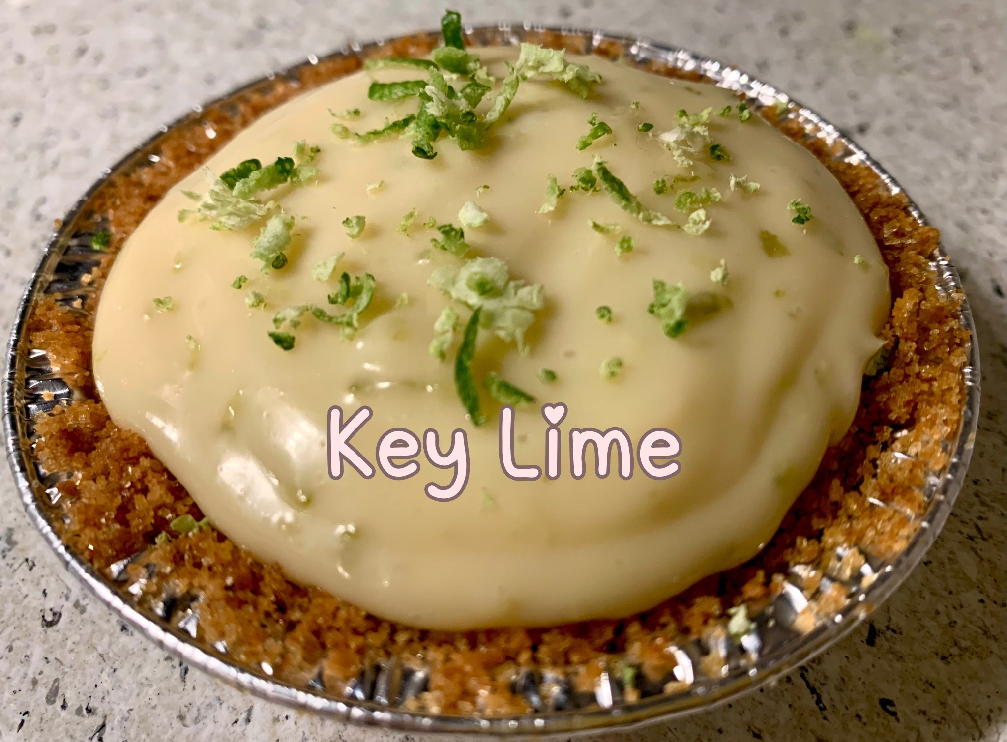 Mini key lime pie with glossy lime glaze and fresh lime zest.