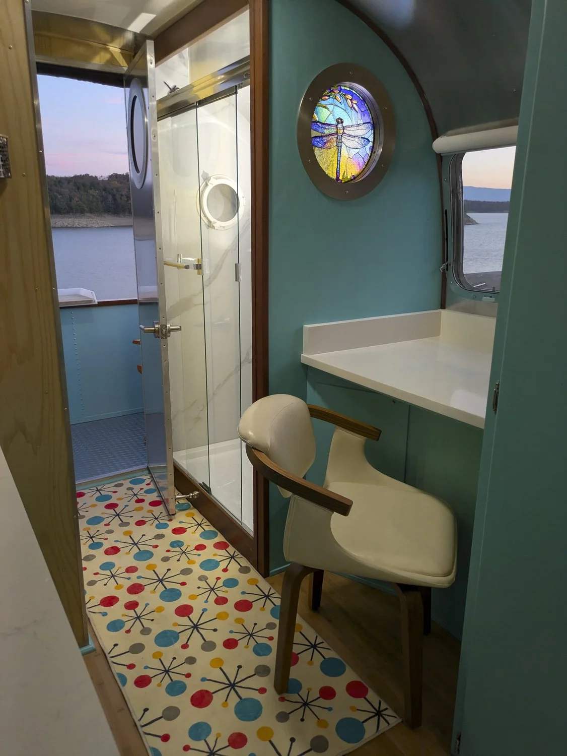Next to the shower is a quartz desk with reading lights and a hinged window. Mid-Century Modern decorating accents can be found throughout the interior. (The shower and desk were added post restoration for the resort that purchased this unit.)