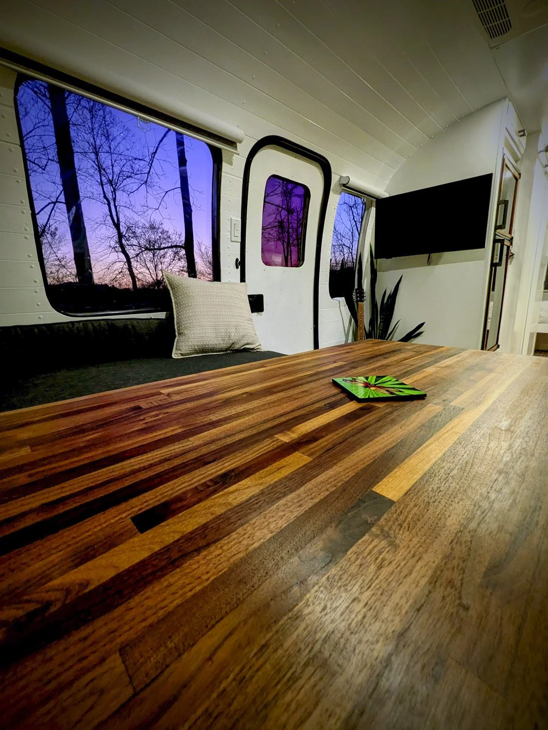 A Custom Butcher Block dining table comfortably seats seven adults and converts into an oversized king bed for flexible guest accommodations.