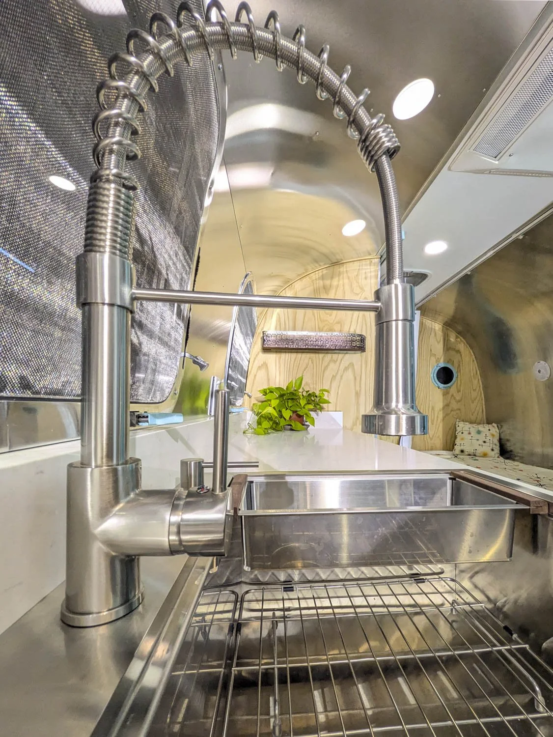 Kitchen features a deep single basin sink and an under-sink water filter. There is also a refrigerator freezer, Retro coffee maker and griddle toaster oven combo. 