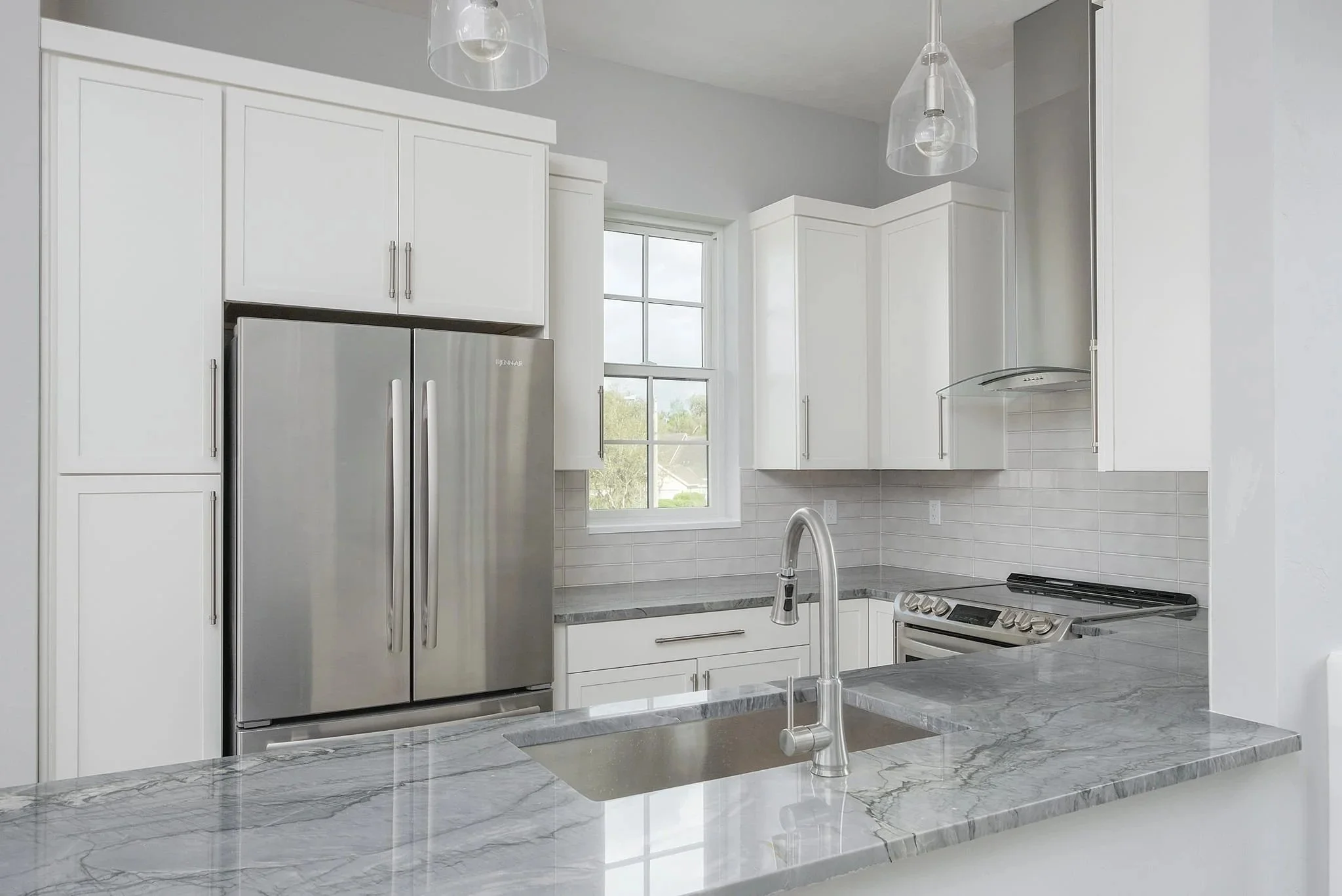 Beautiful kitchen with white cabinets and marble countertops. Reliable Painting Interior Paint Gainesville, Florida