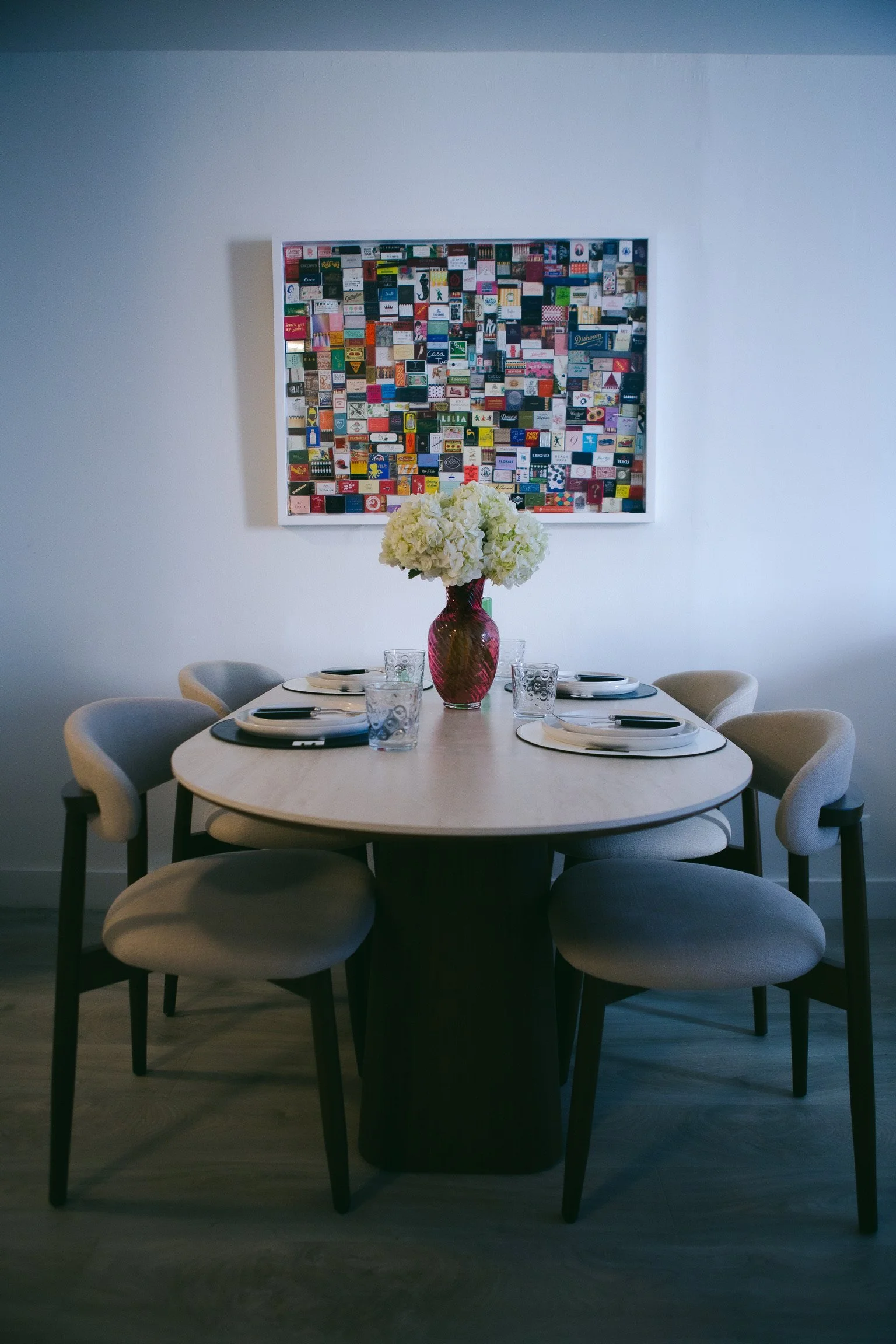 A dining table set with chairs and a vase of colorful flowers in the center, creating an inviting atmosphere.