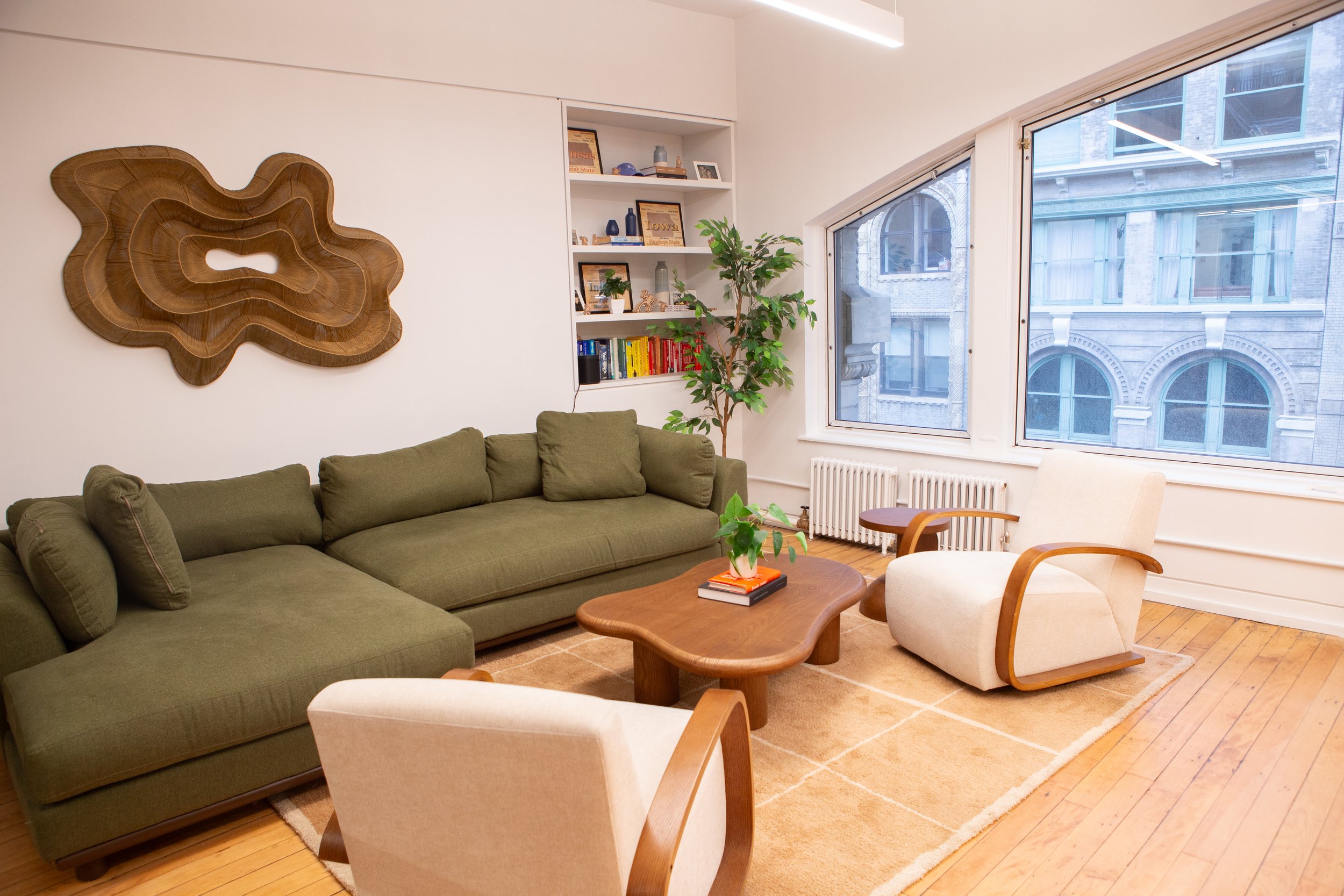 Interior of a living room with a couch, coffee table, and wall art, located in the Flatiron Office.