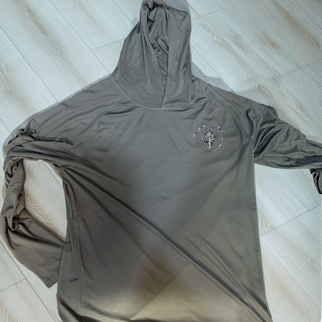 Close-up of custom left-chest branding on a raglan sleeve performance sun hoodie, demonstrating sharp graphic detail and precise alignment.