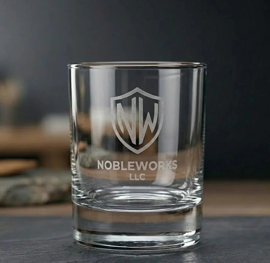 Artisan etched whiskey glass featuring a permanent frosted NobleWorks LLC logo. Premium custom glassware and engraved barware in Appleton, WI.