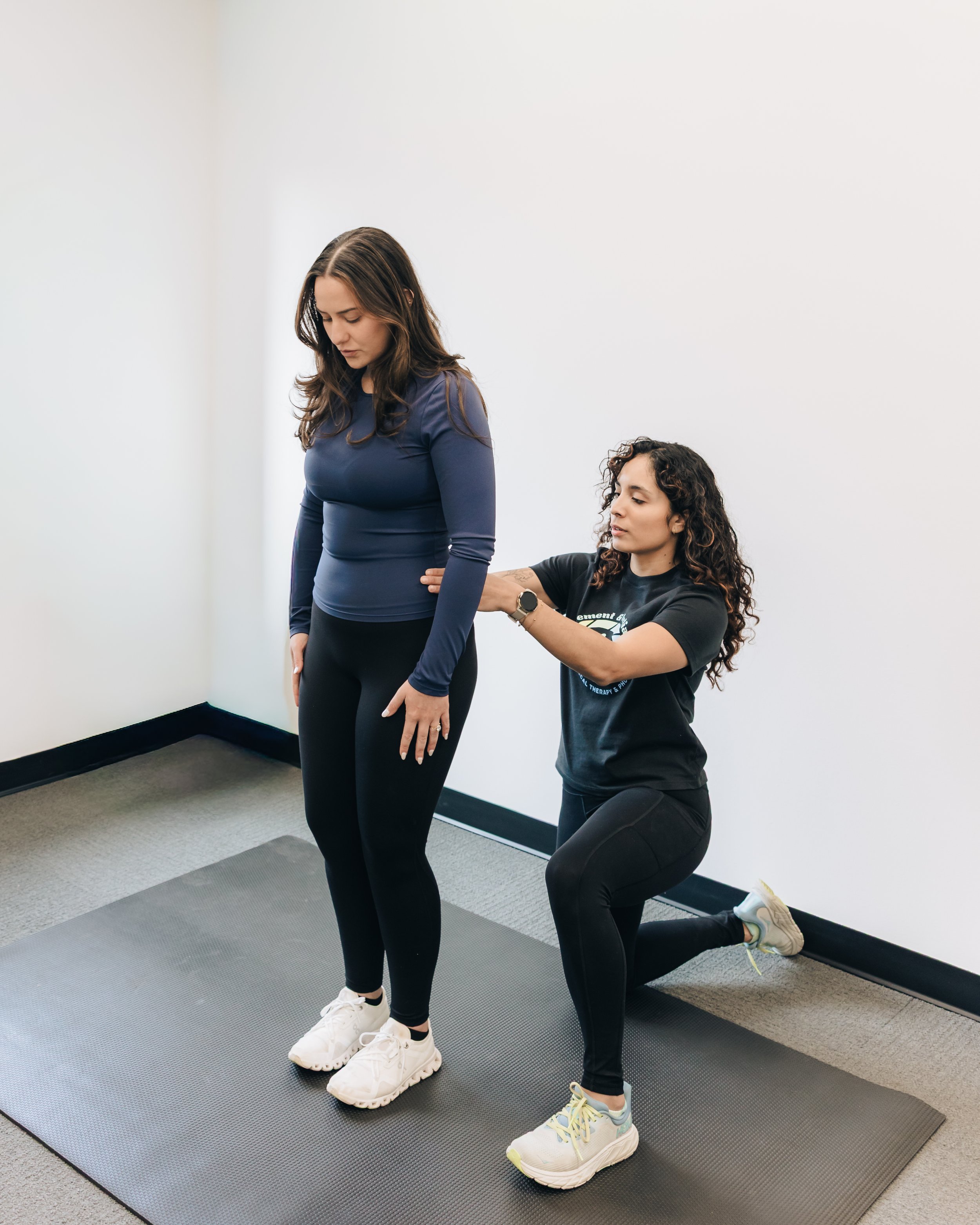 Image of a physical therapist assessing a patient's posture in a clinic.