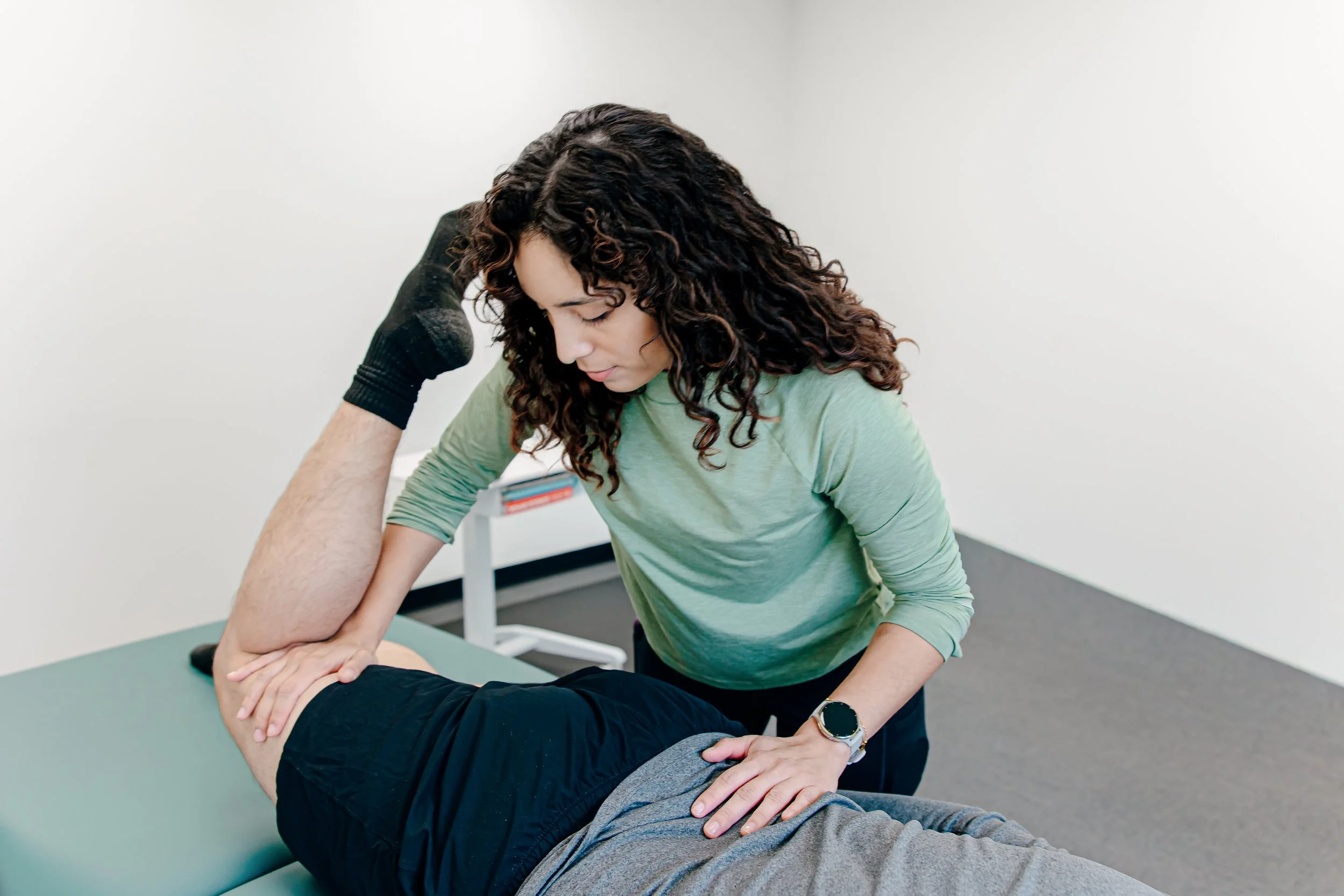 Photo of a physical therapist working with a patient on a treatment table.