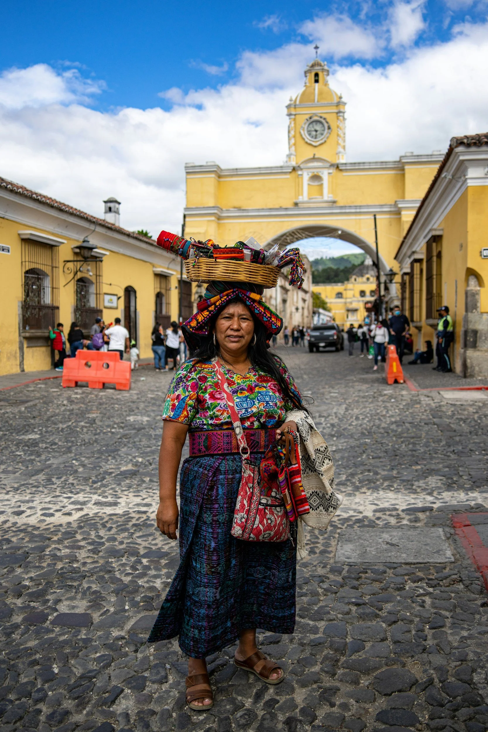 a local Guatemala woman in traditional clothes and a basket over her head posing for picture